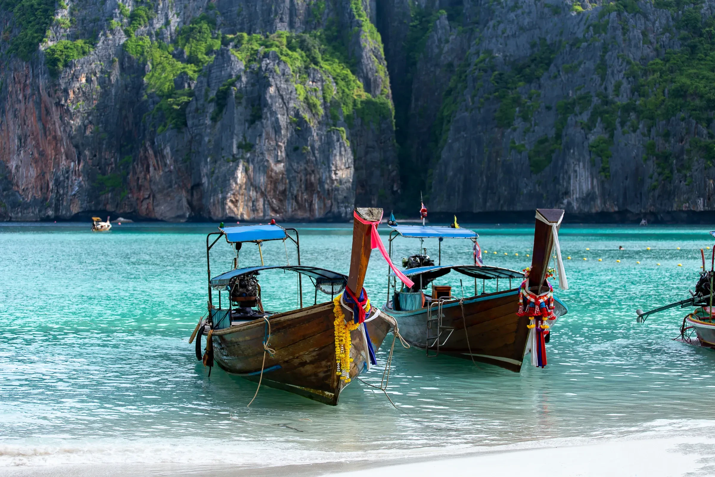 Longtail boats in front of the limestone cliffs on Koh Phi Phi Leh