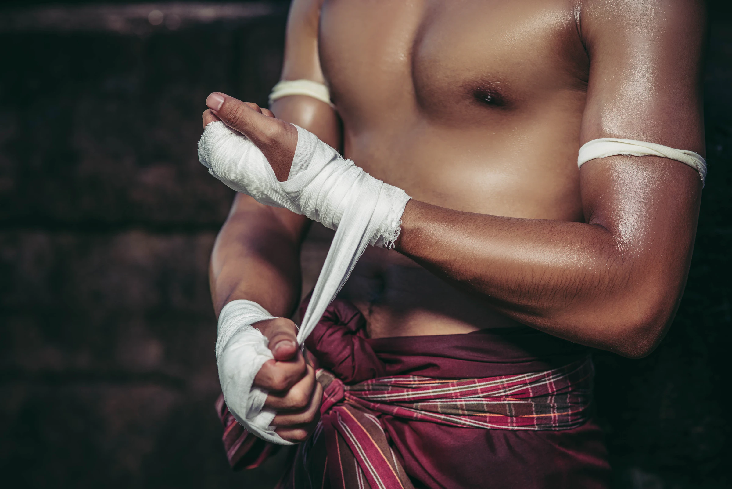 A boxer wrapping his hands before a Muay Thai fight