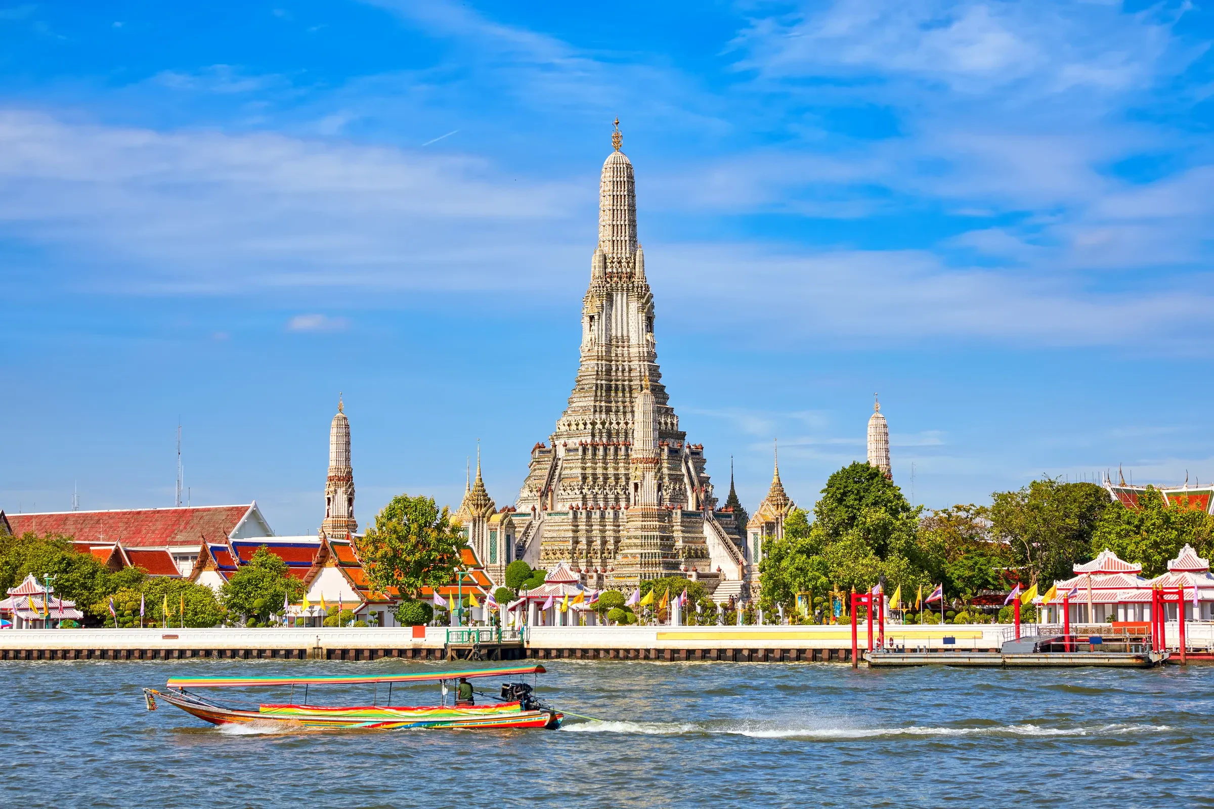 Wat Arun beside the Chao Phraya river with a longtail boat in front, Bangkok