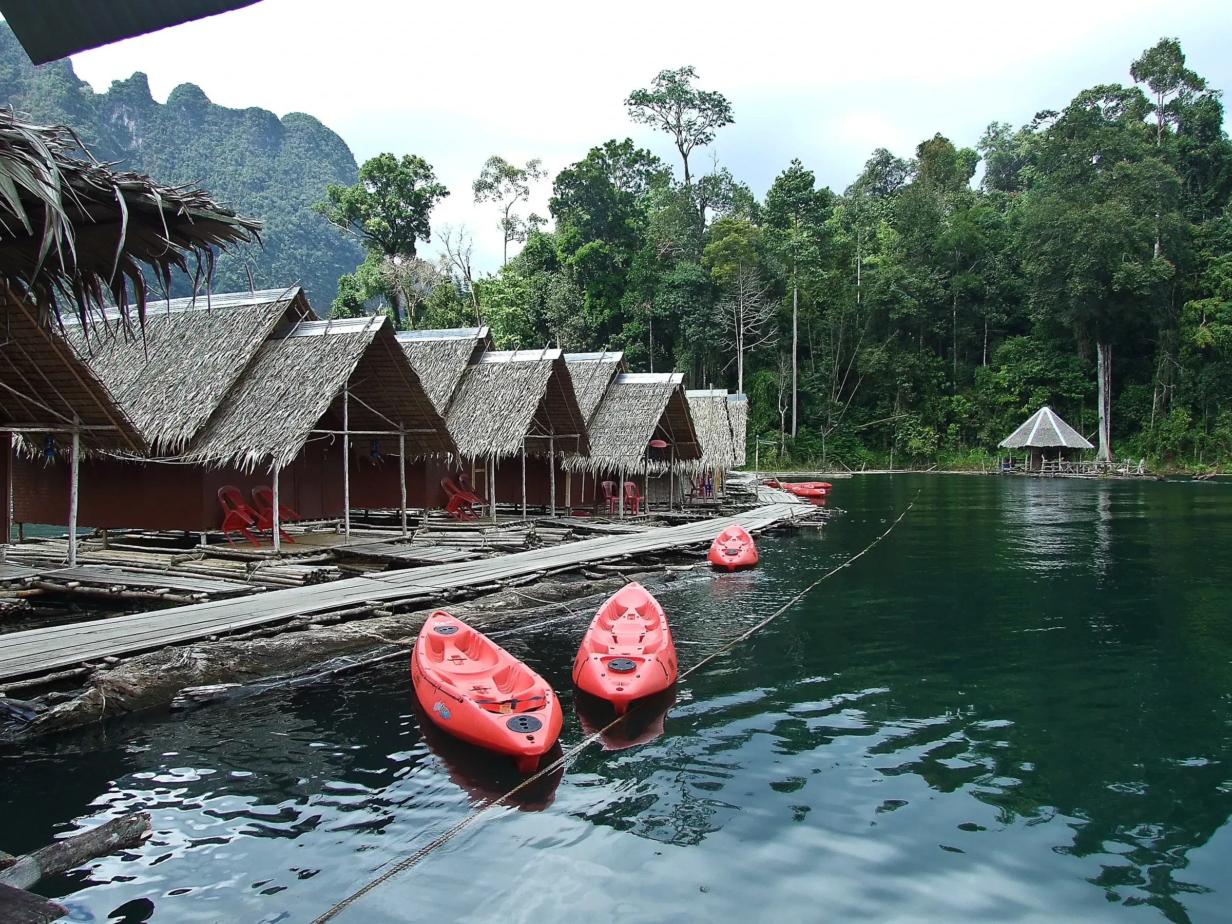 Raft houses and red kayaks on Cheow Lan Lake in Khao Sok National Park