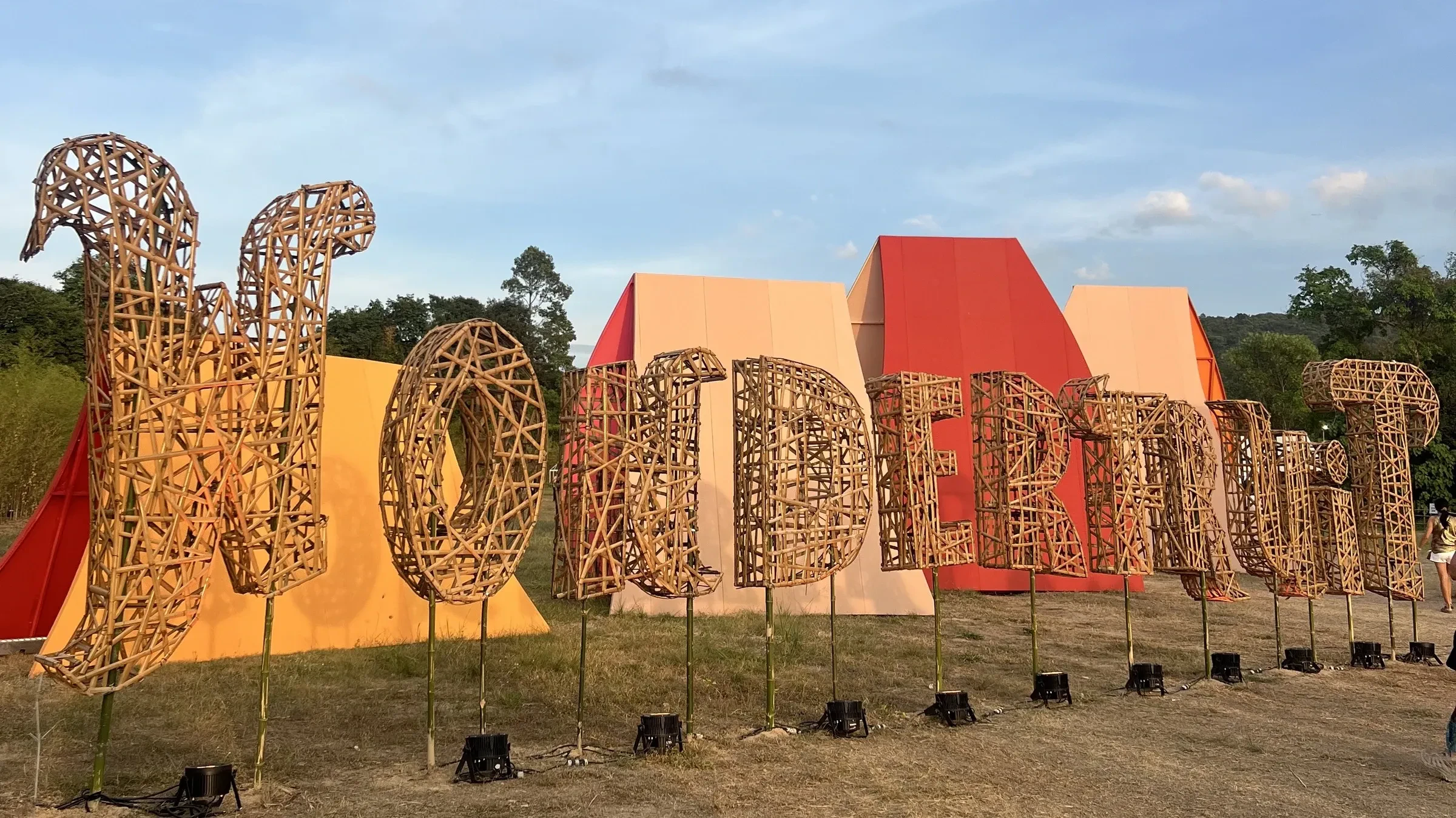 The Wonderfruit welcome sign in carved wooden letters at The Fields