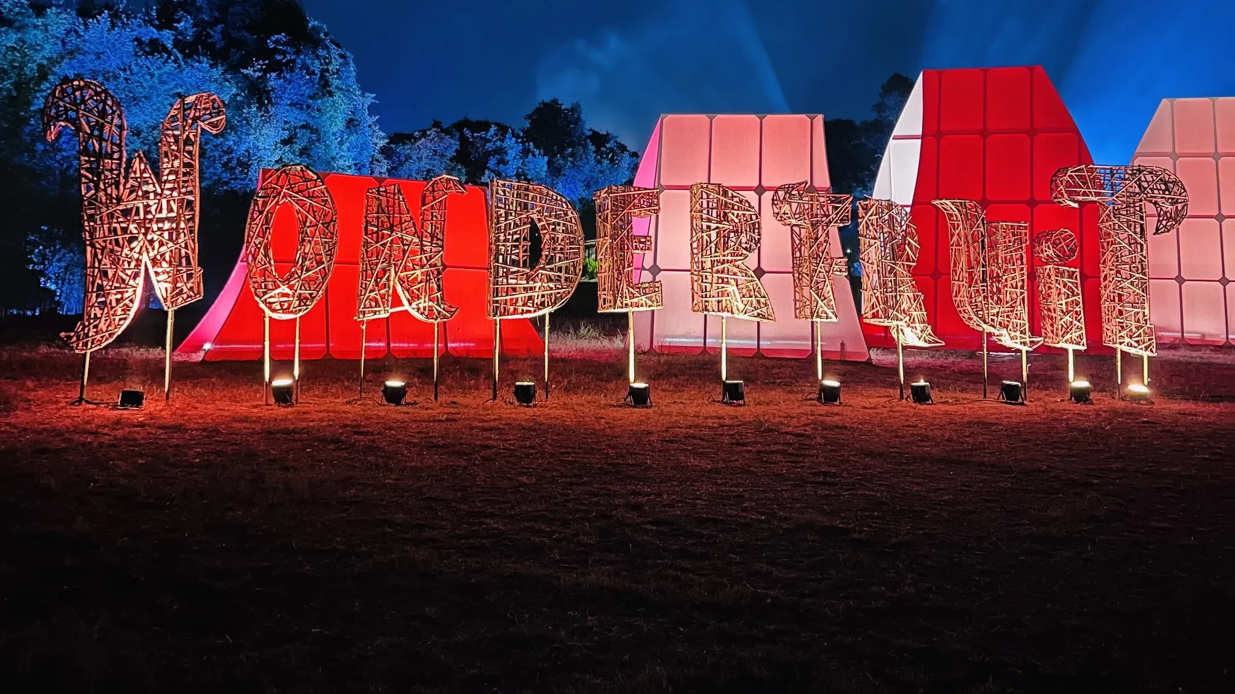 The Wonderfruit sign lit up in the evening at The Fields