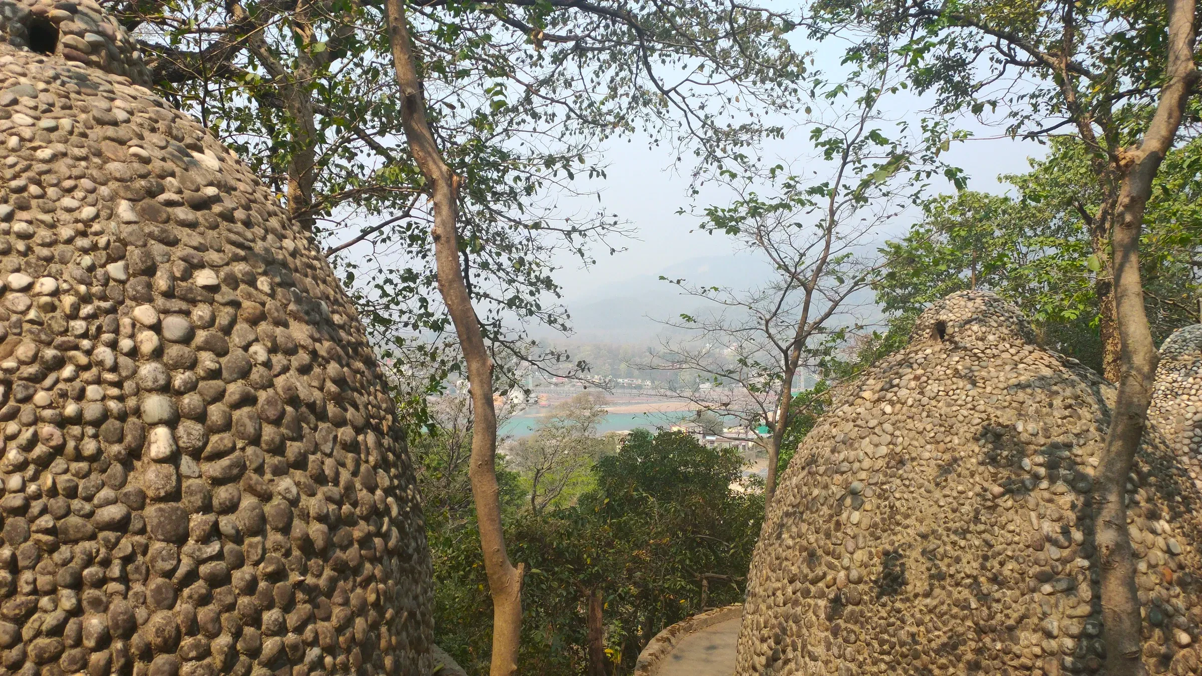 Round pebble-covered domes among trees at the Beatles Ashram in Rishikesh