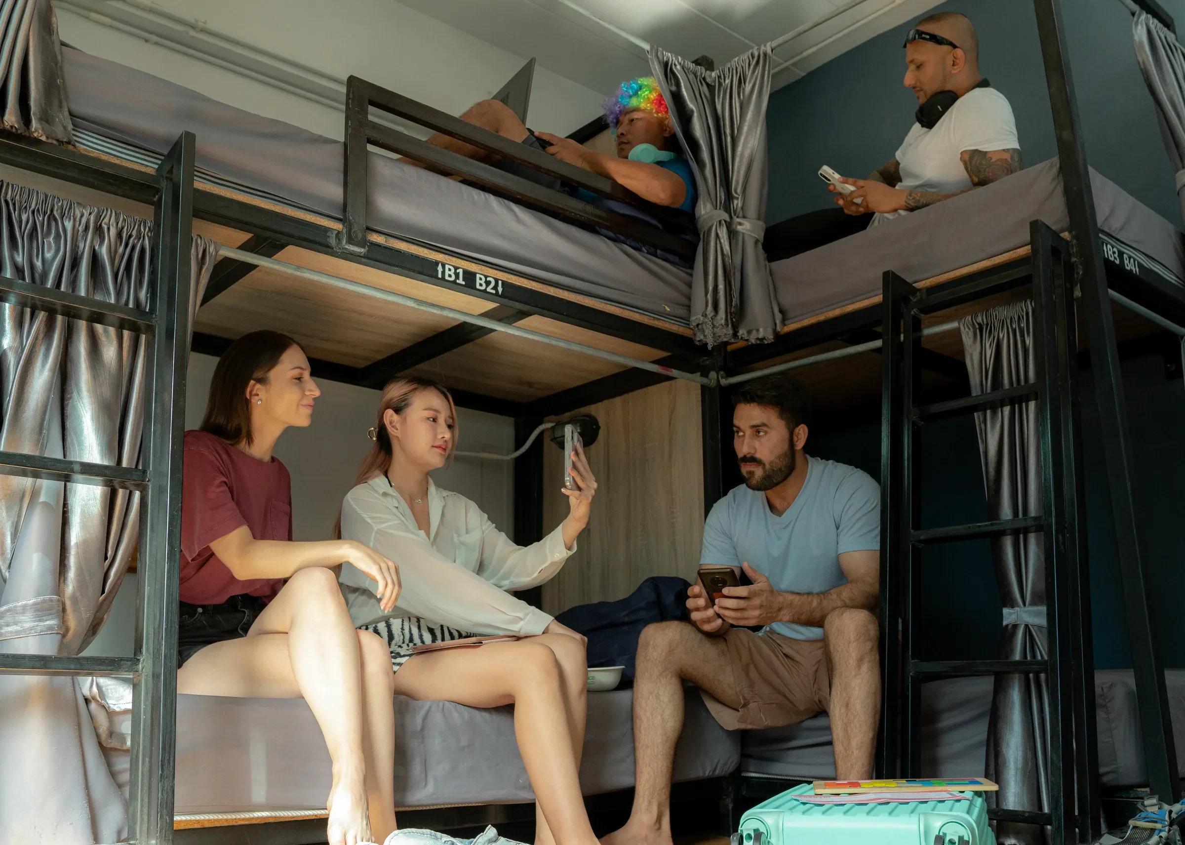 Travellers sitting on bunk beds in a hostel dorm room