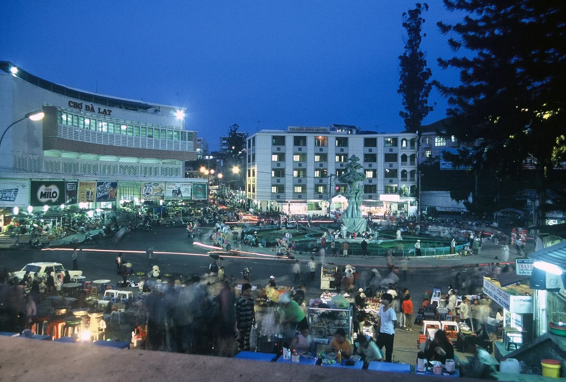 Food stalls and light trails at Da Lat market square at dusk