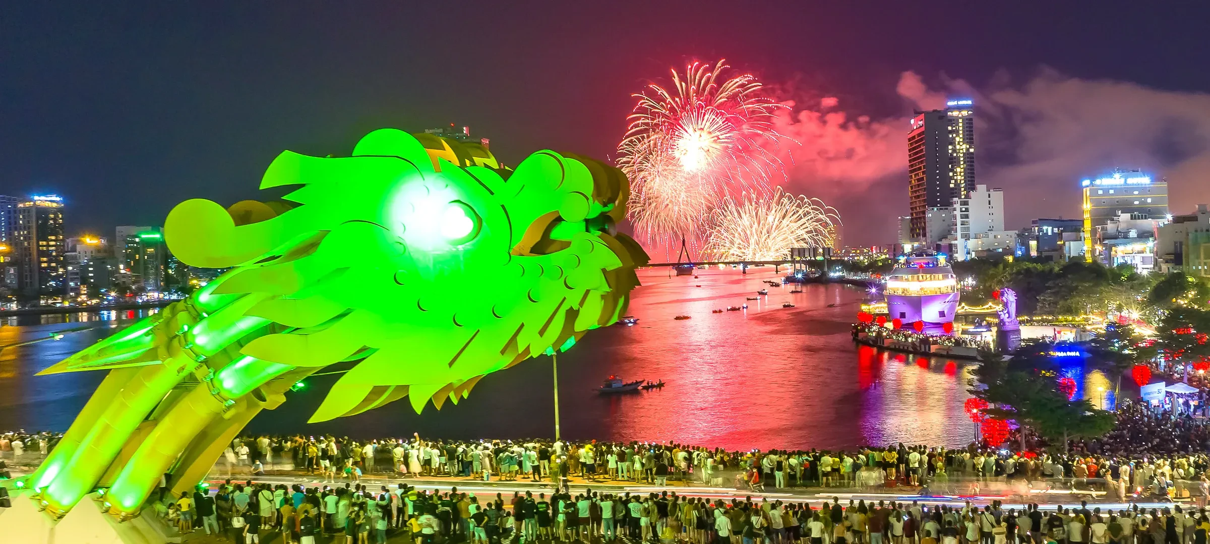 Crowds on the Dragon Bridge watching fireworks beside the glowing dragon head, with the Han River below