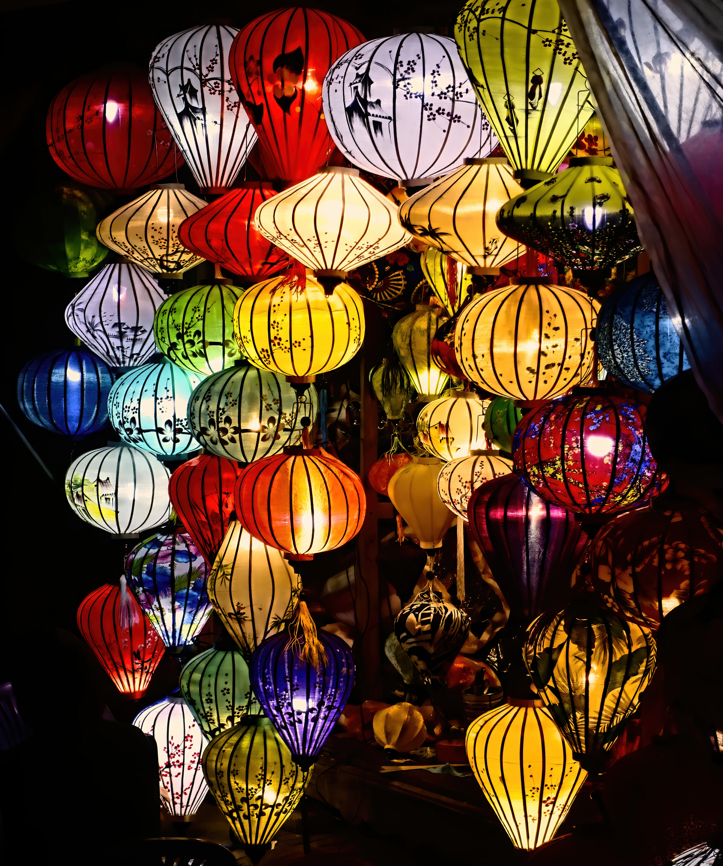 Silk lanterns in many colours hanging at a night market stall in Hoi An