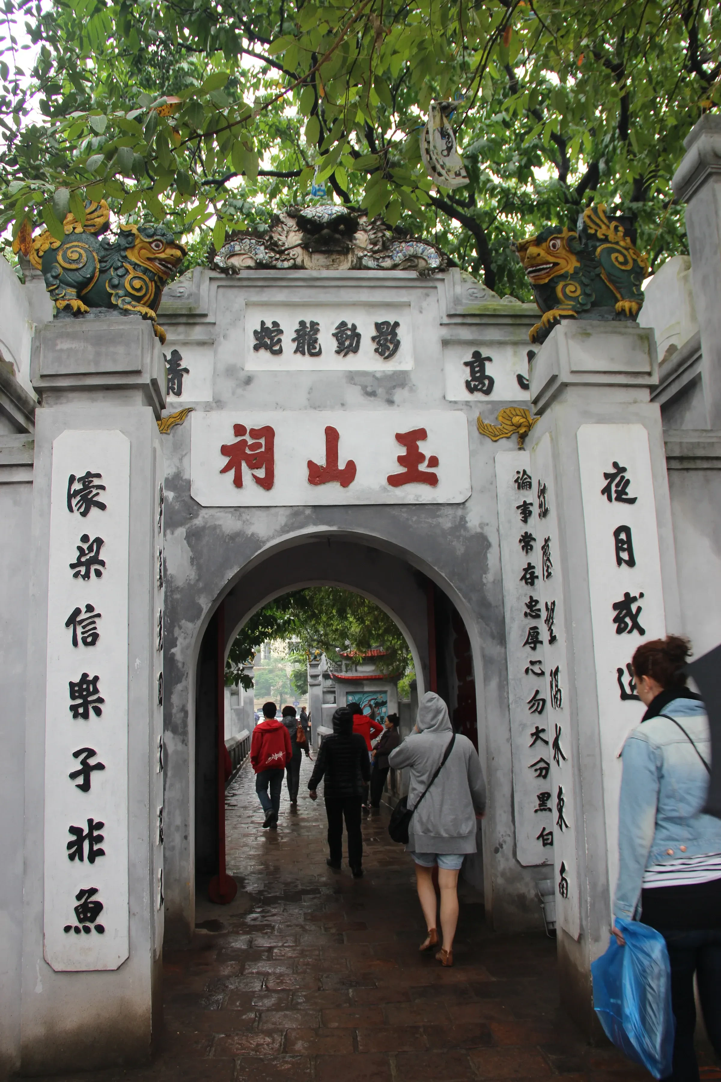 An old stone gate with Chinese characters leading to Ngoc Son Temple on Hoan Kiem Lake in Hanoi