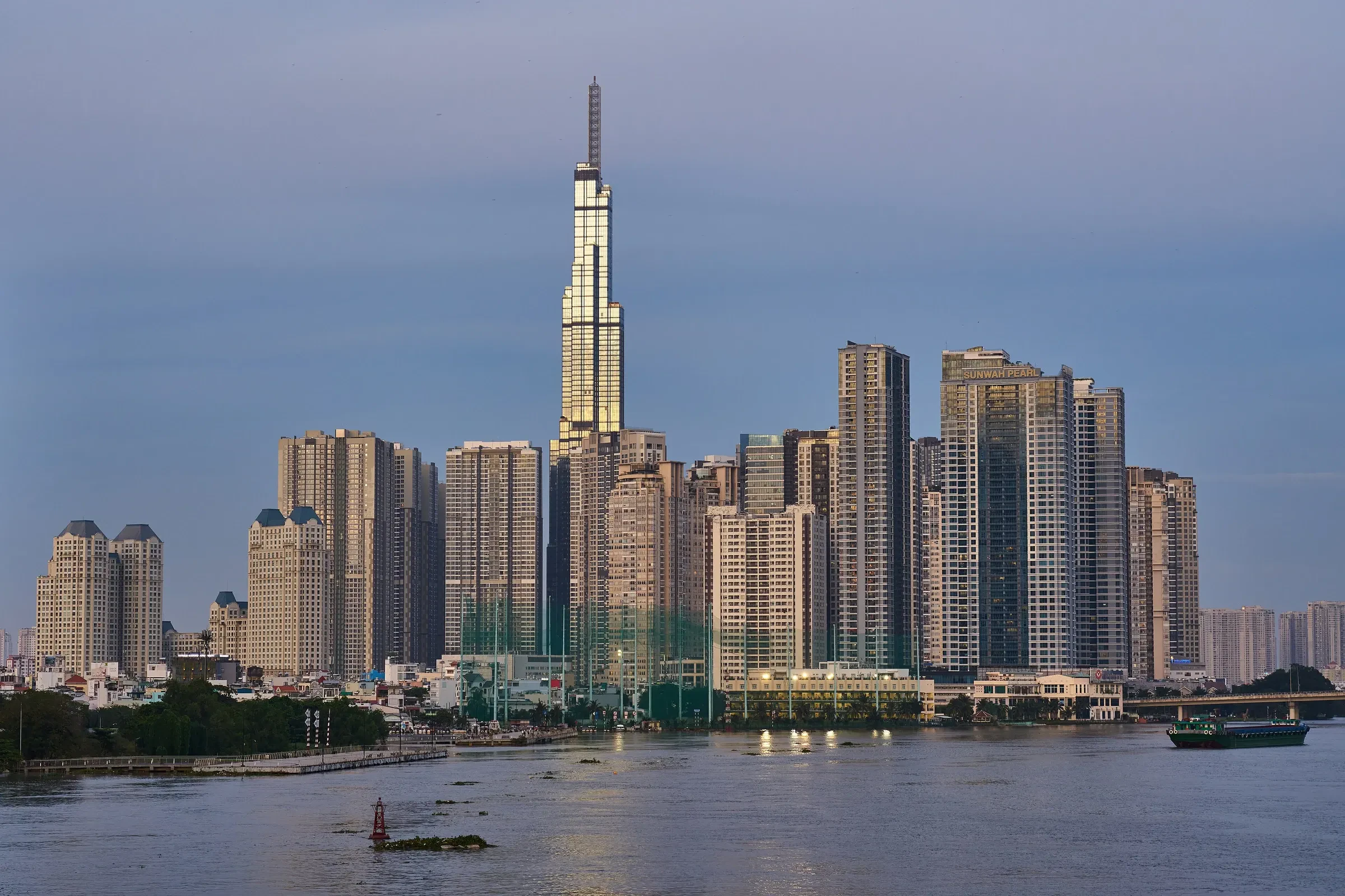 The Saigon skyline and river at dusk, with a tall skyscraper