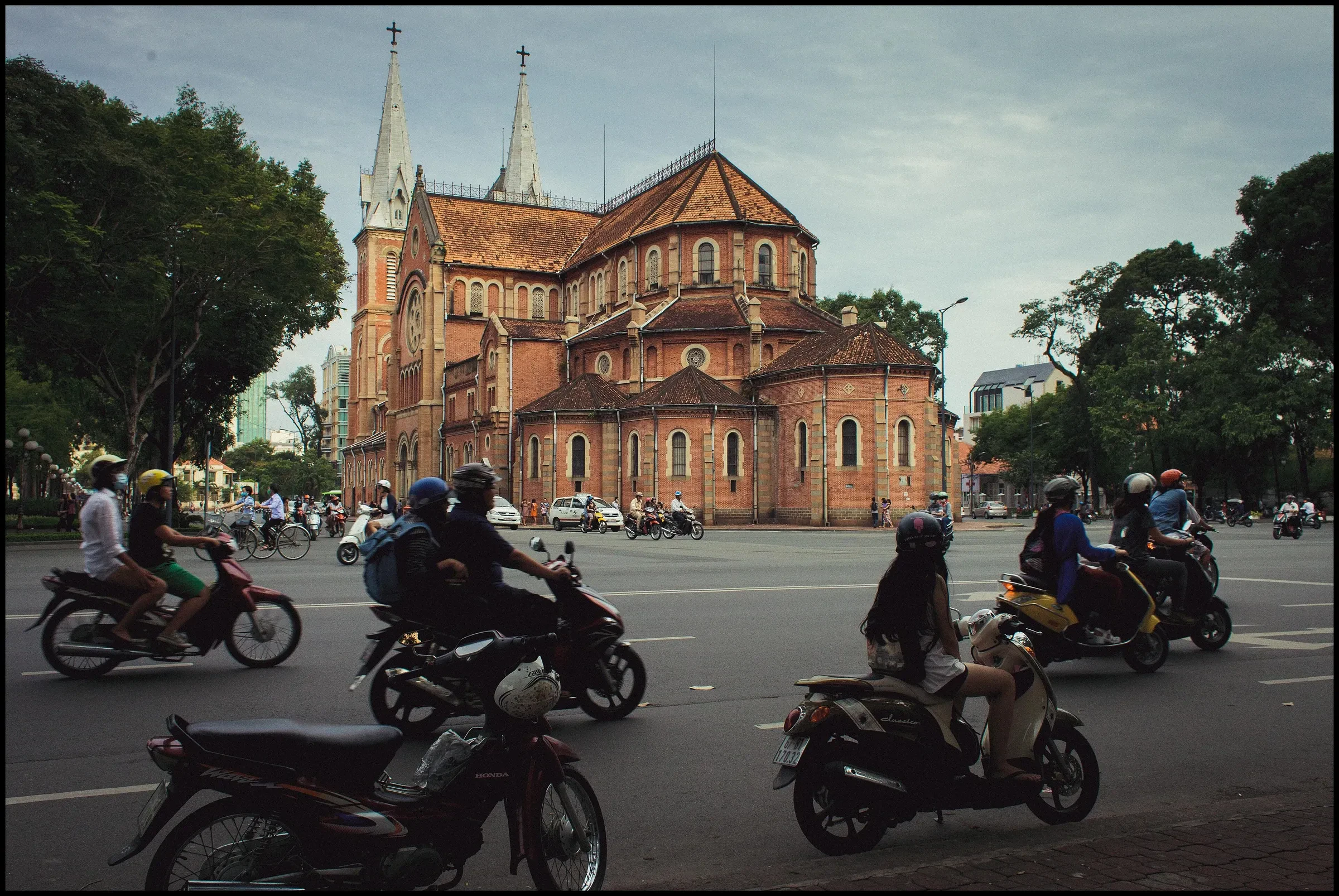 Scooters passing Notre-Dame Cathedral Basilica in Ho Chi Minh City