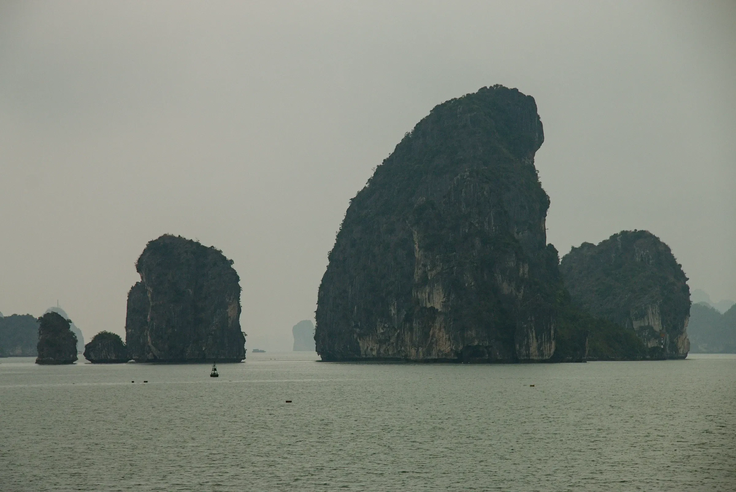Limestone islands rising from calm water in Bai Tu Long Bay