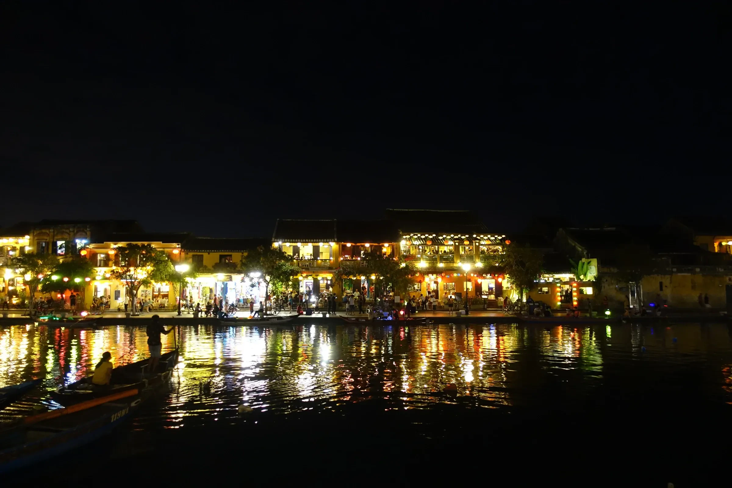 Hoi An's riverside old town lit up at night and reflected in the water