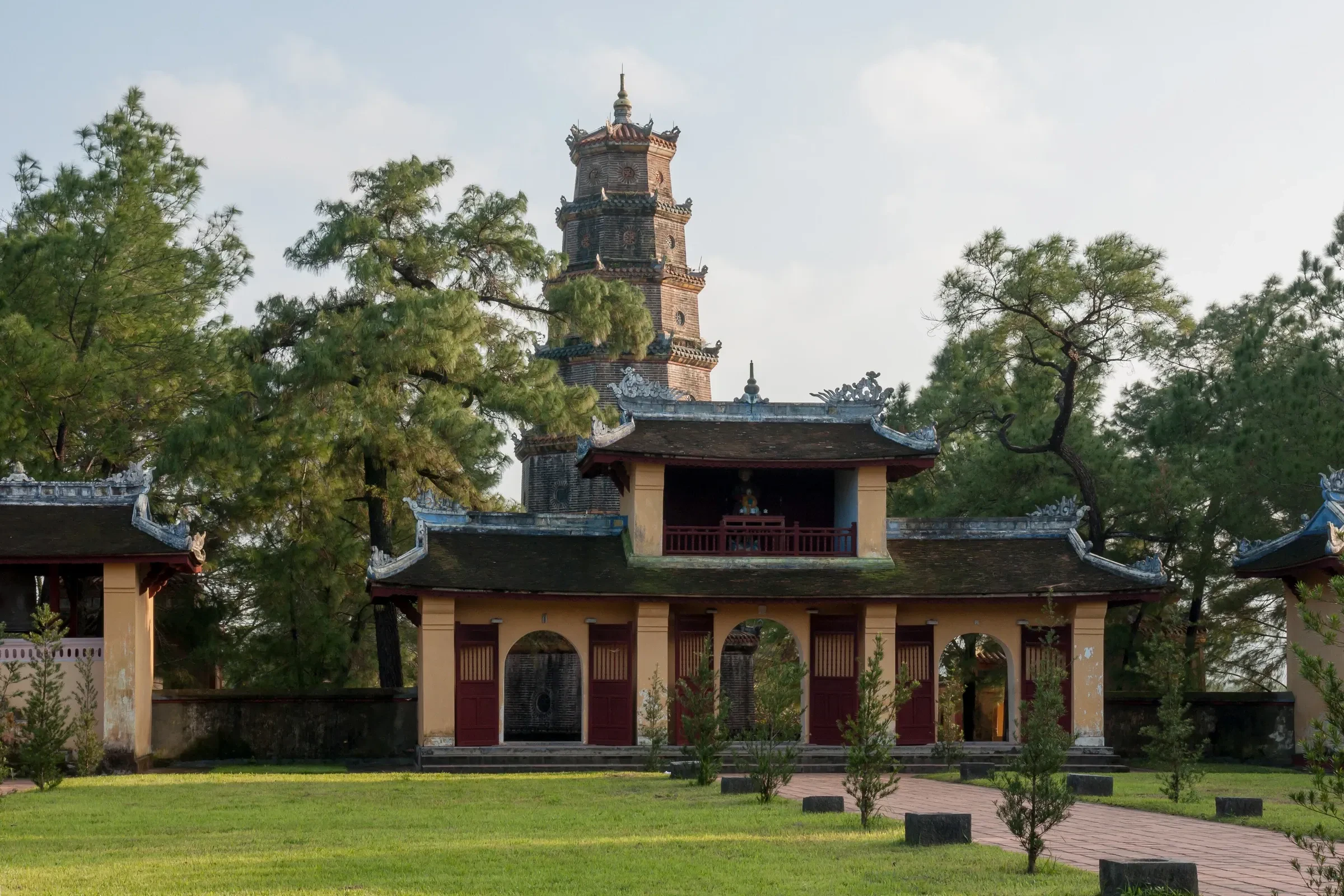 Thien Mu Pagoda's tower rising behind a temple hall in Hue