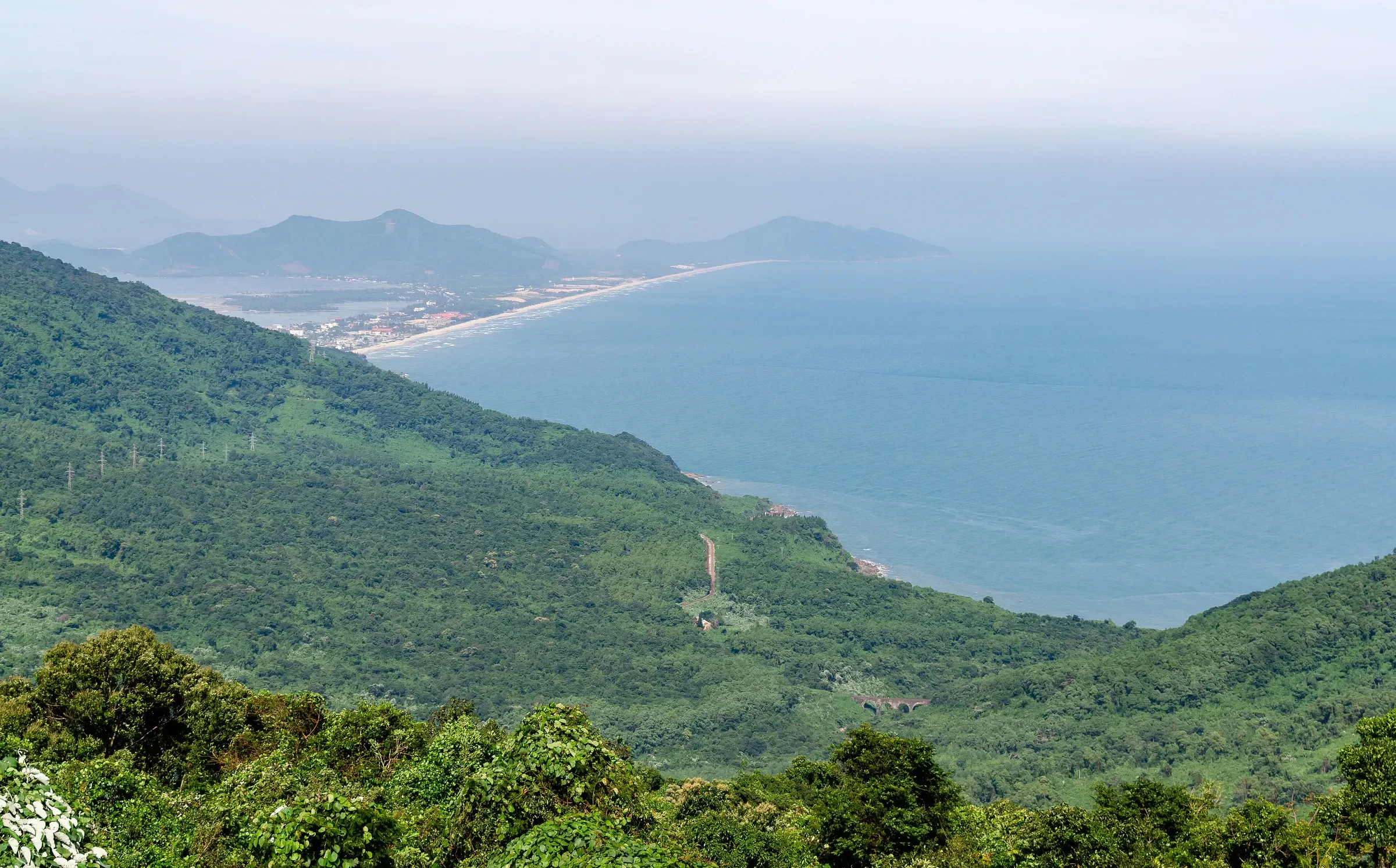 Green mountainside above the coast and Lang Co bay from the Hai Van Pass