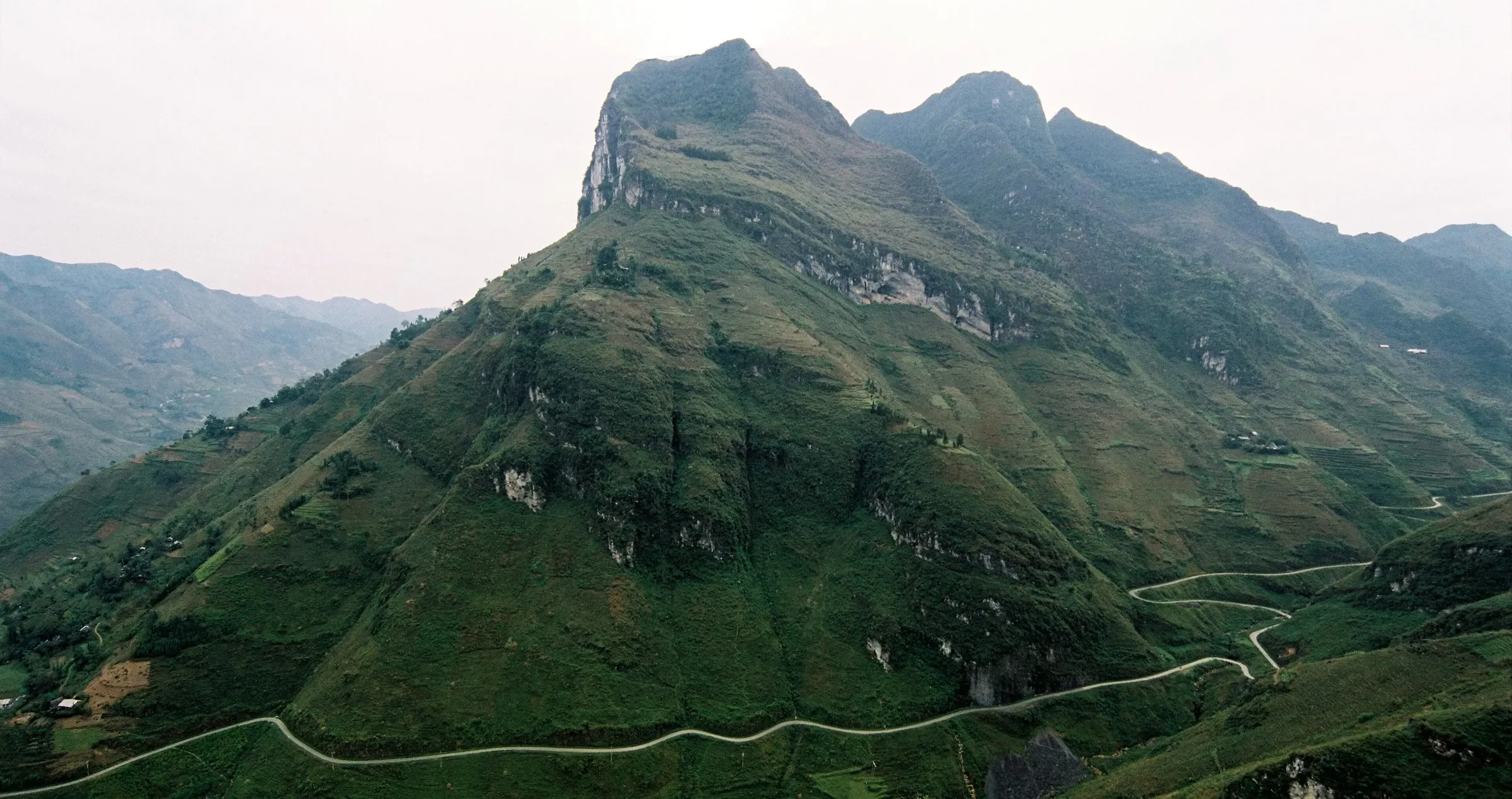 The road winding along the mountainside at Ma Pi Leng Pass in Ha Giang