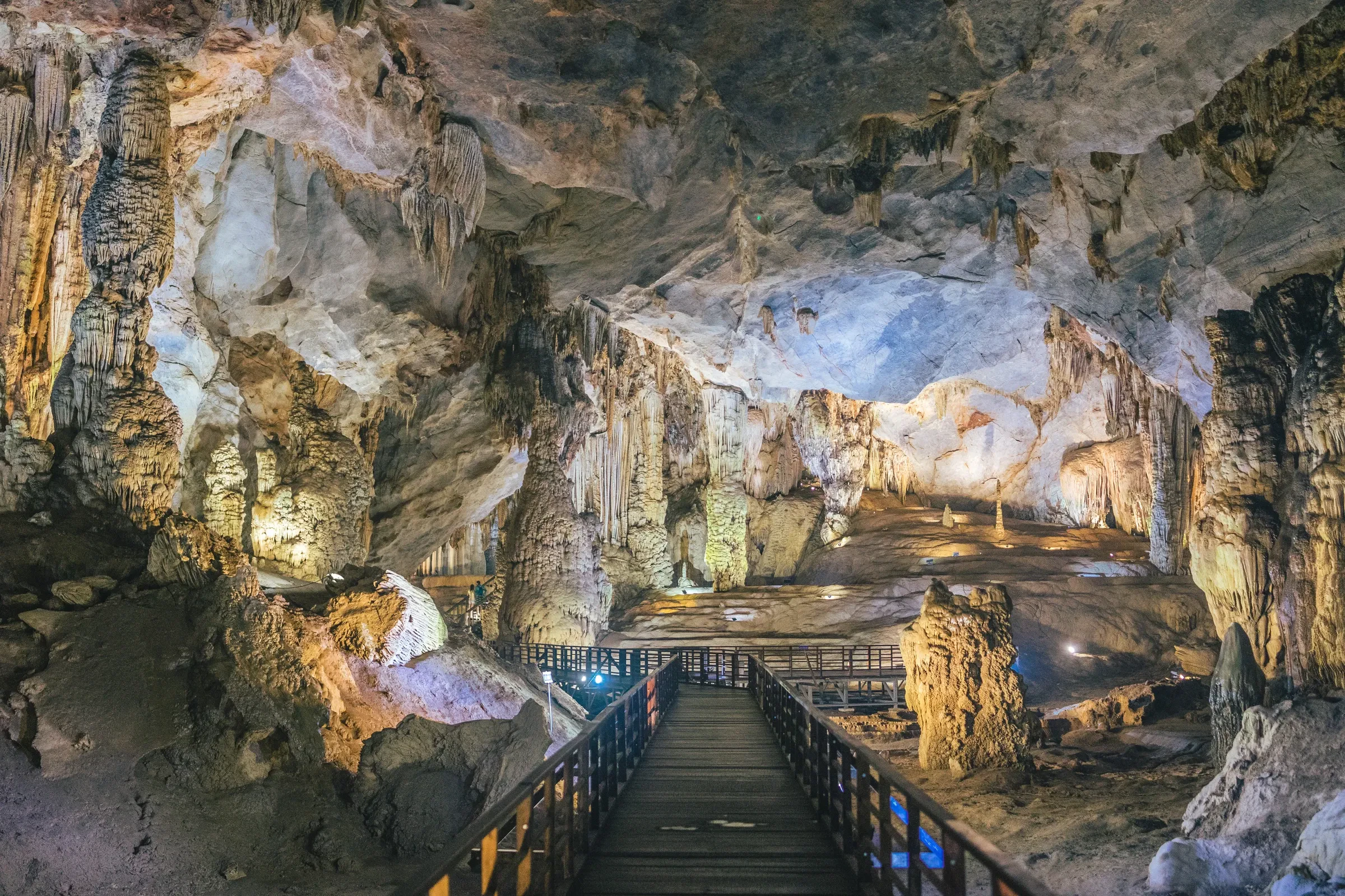 The wooden boardwalk winding through the lit stalactite chambers of Paradise Cave