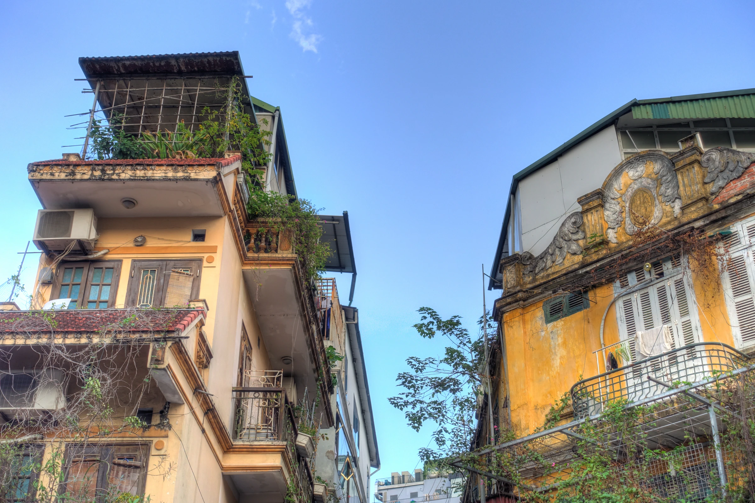 Weathered yellow buildings with balconies in Hanoi's Old Quarter, the starting point for almost every Vietnam itinerary