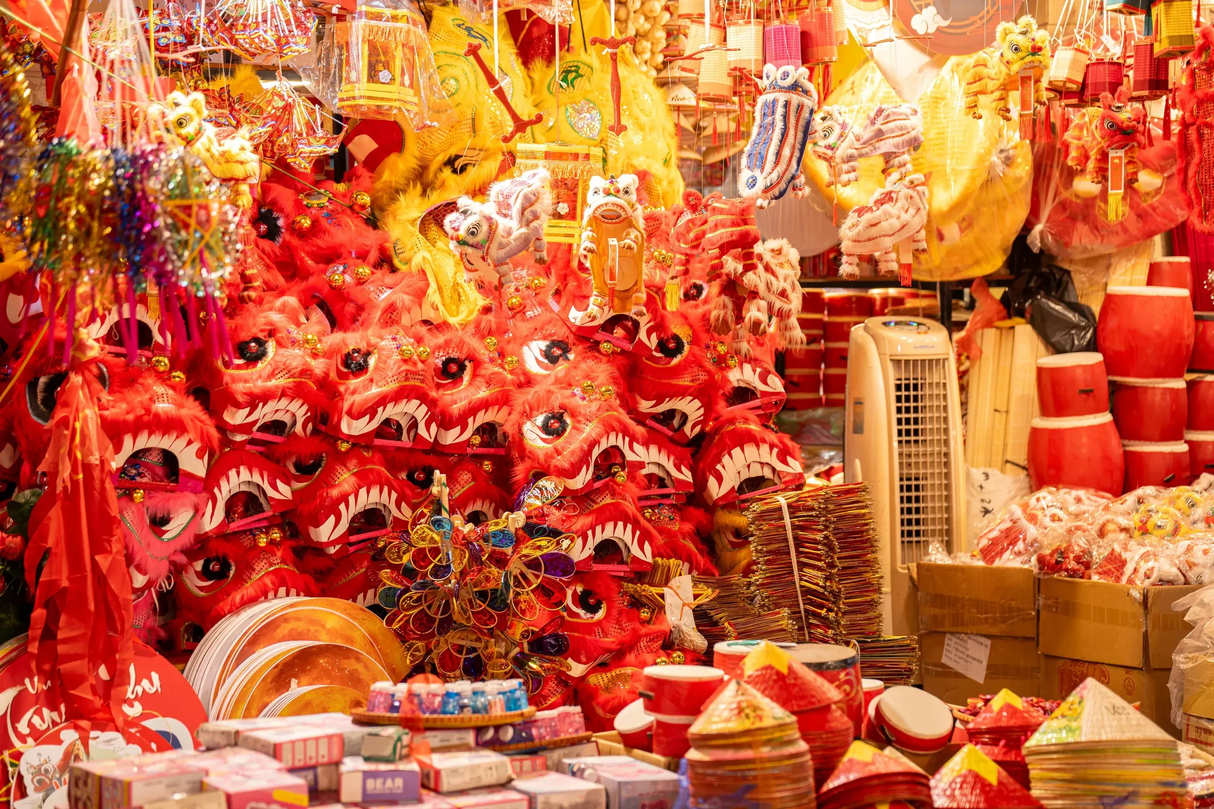 Lion-head masks, lanterns and toys hanging at a stall on Hang Ma street in Hanoi