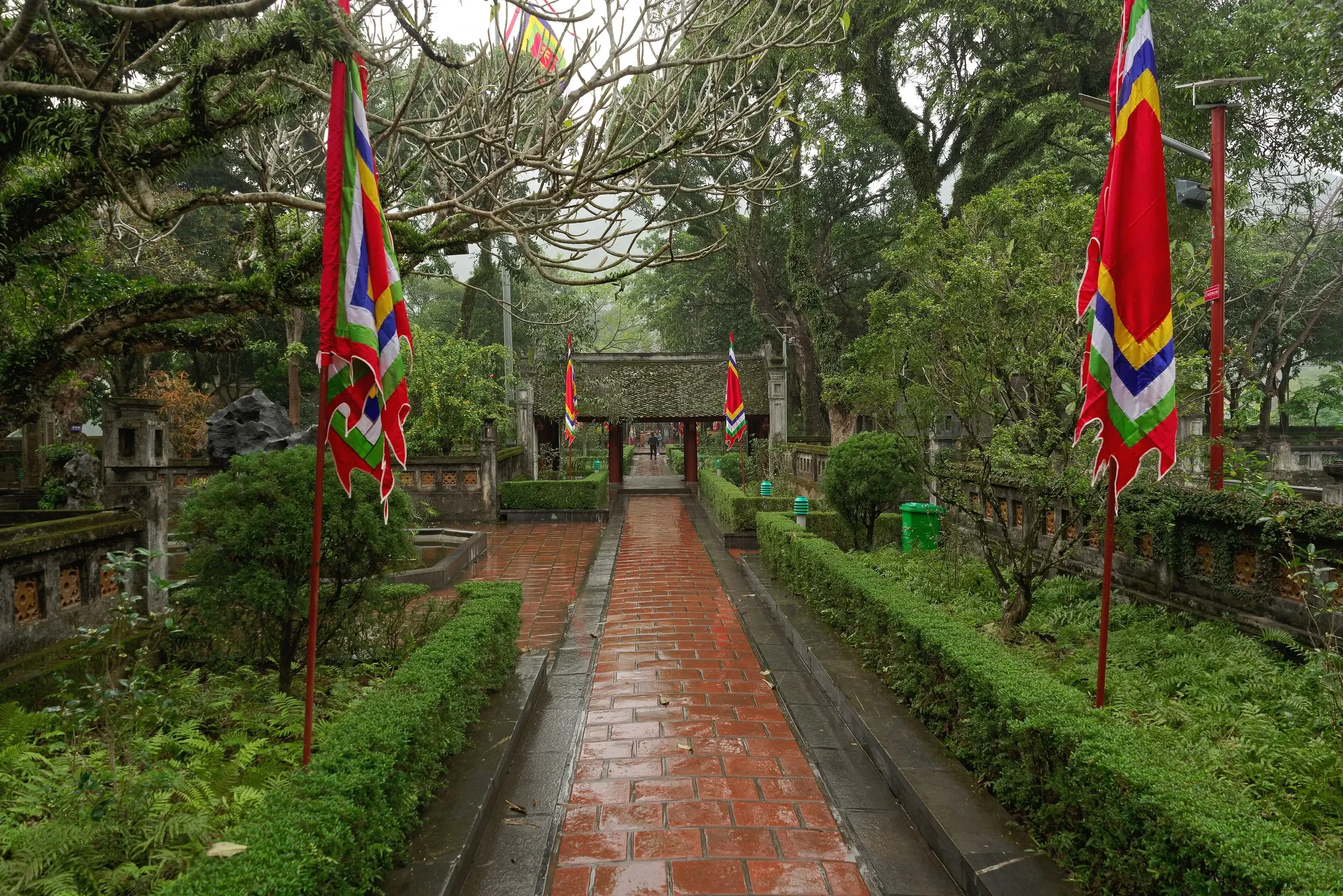 A brick path lined with flags leading to a temple gate at the Hoa Lu ancient citadel