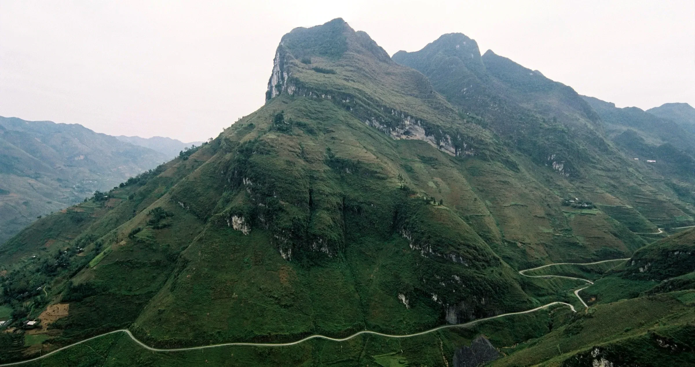 The road winding along the mountainside at Ma Pi Leng Pass in Ha Giang Province