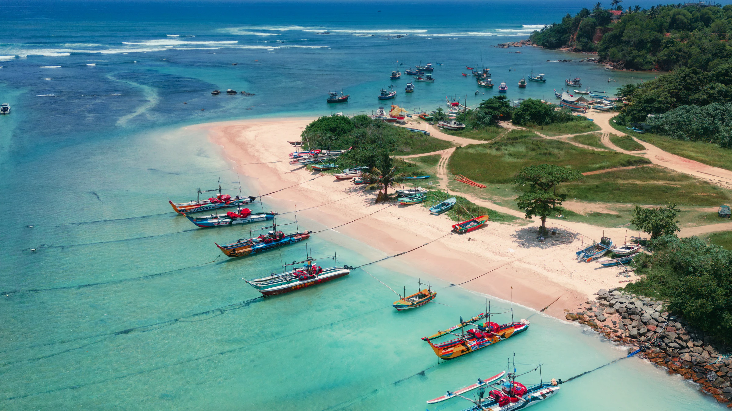 An aerial view of a sandy beach and colourful fishing boats on the south coast near Weligama