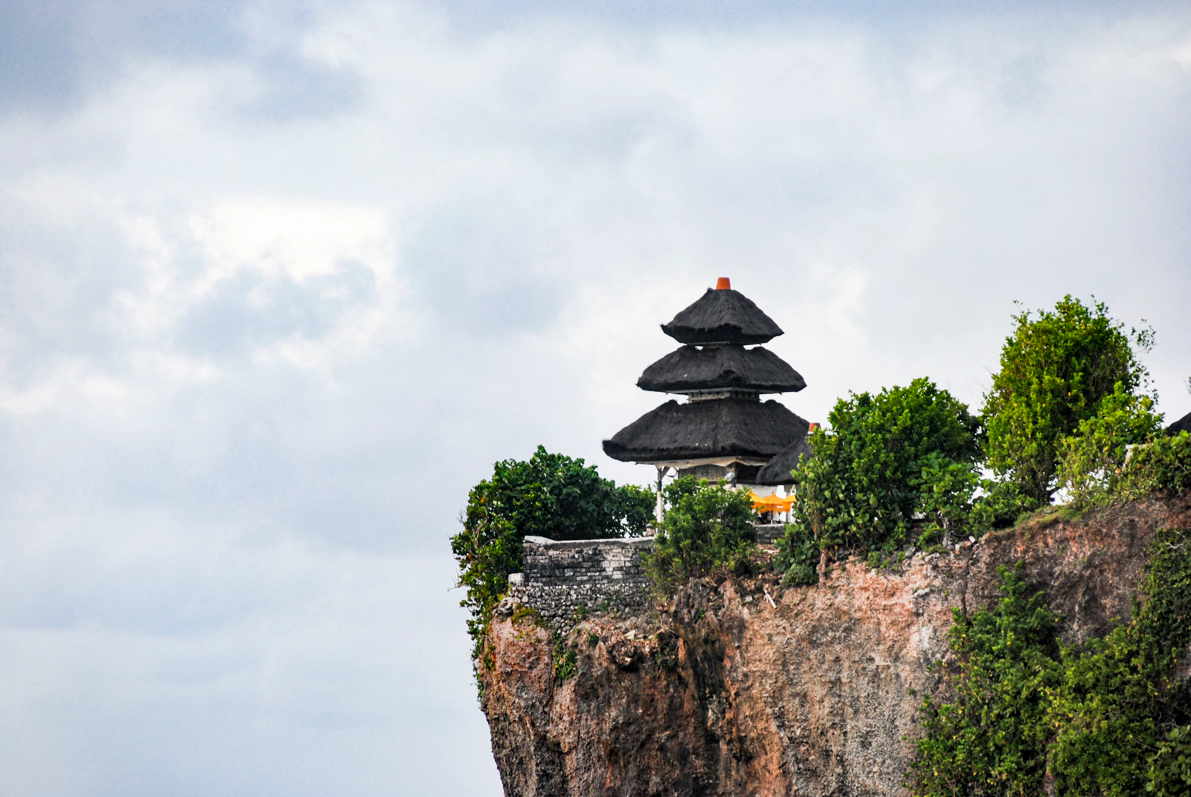 The tiered roof of Uluwatu Temple on the edge of a sea cliff in Bali