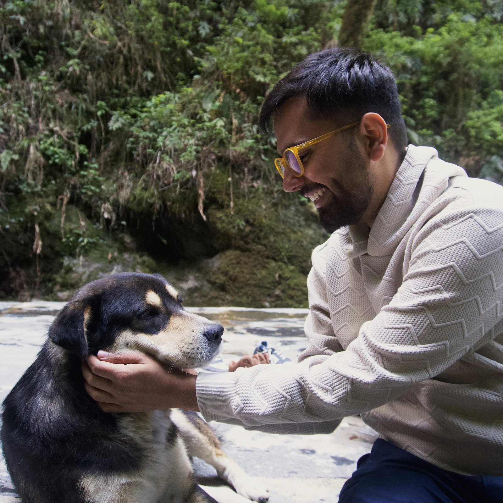 Sarthak laughing as he pets a dog
