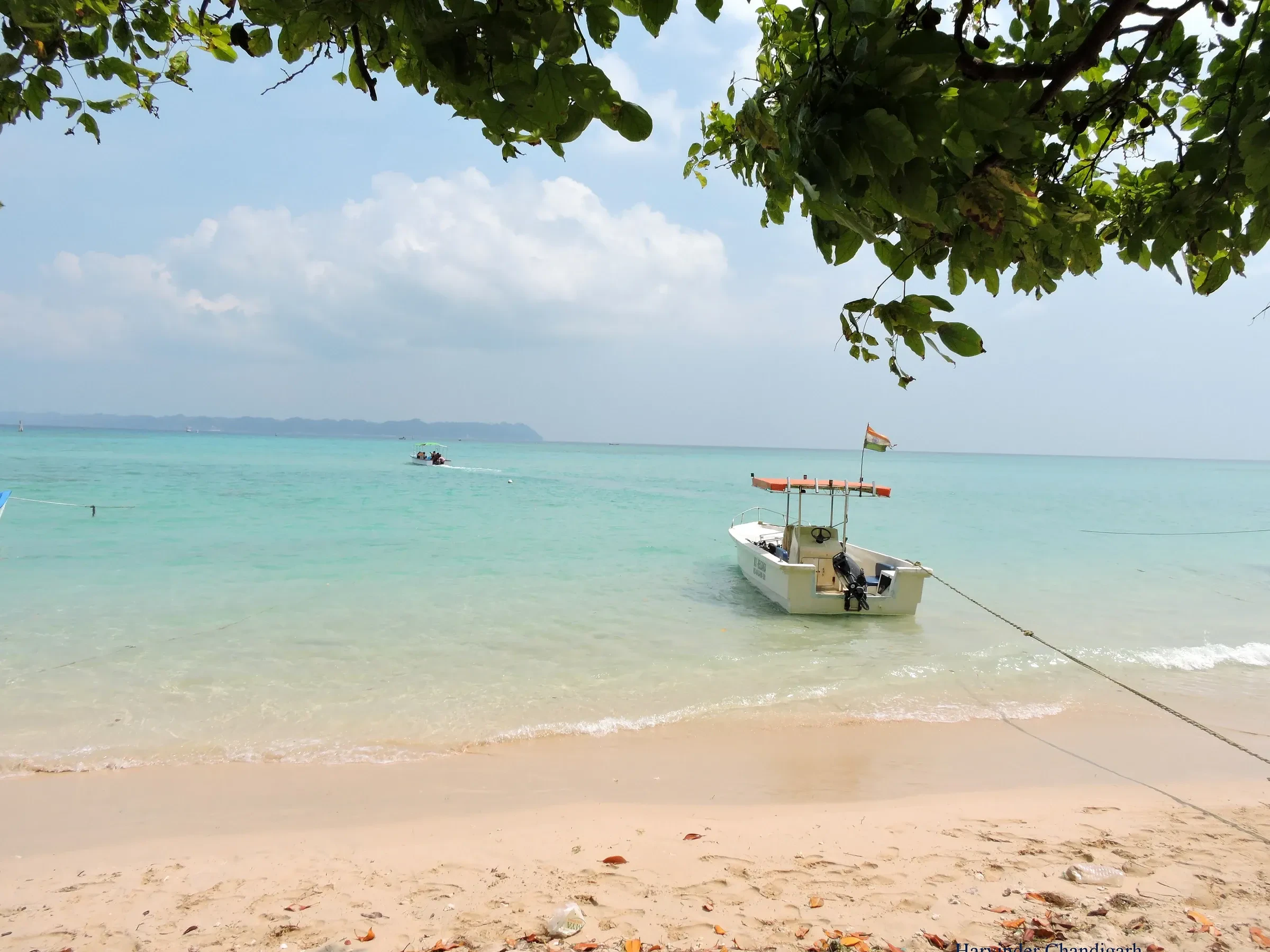 A boat at anchor in the shallow turquoise water off Bharatpur Beach on Neil Island