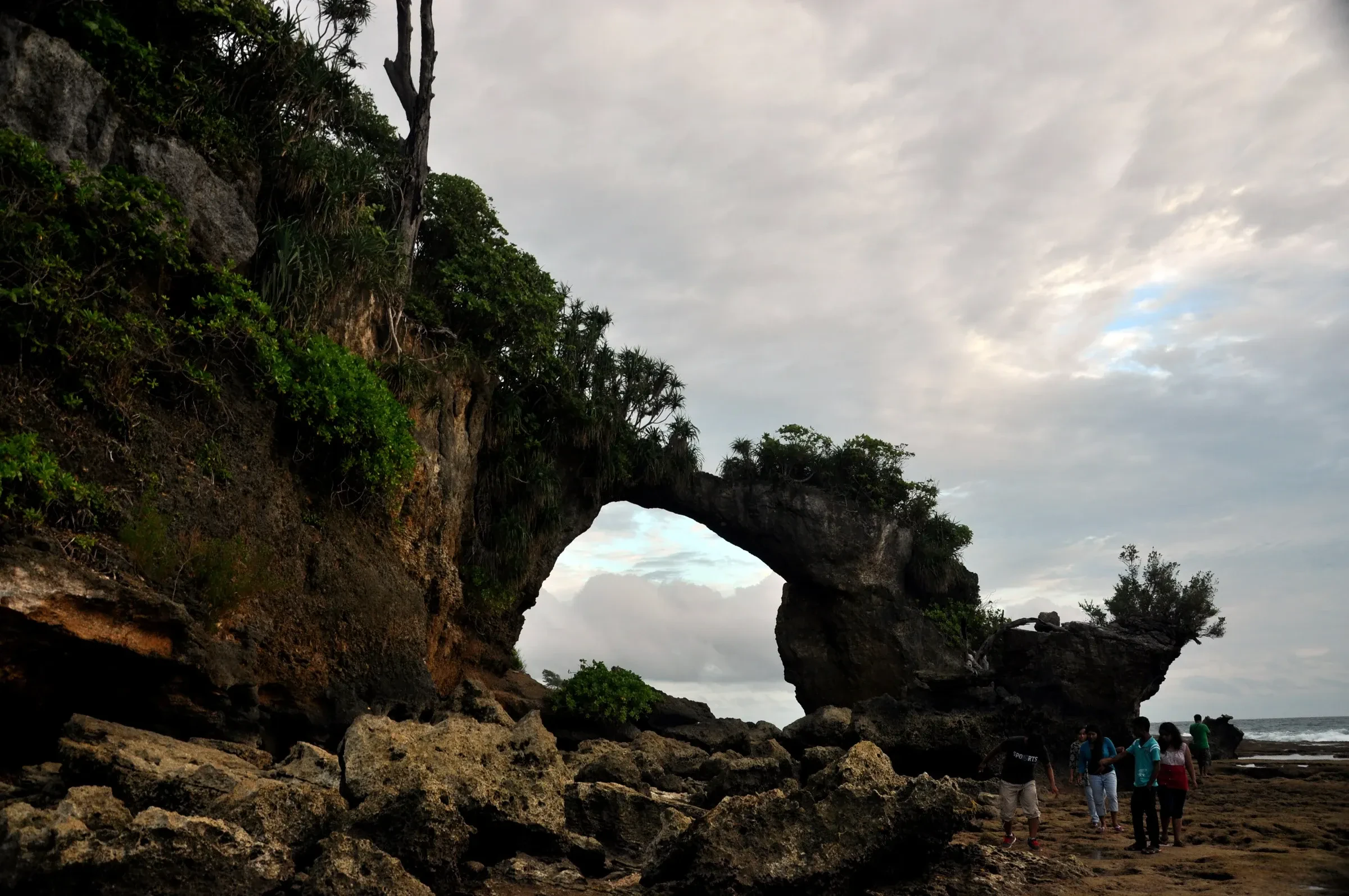 The Natural Bridge at low tide on Neil Island, with people walking out towards it