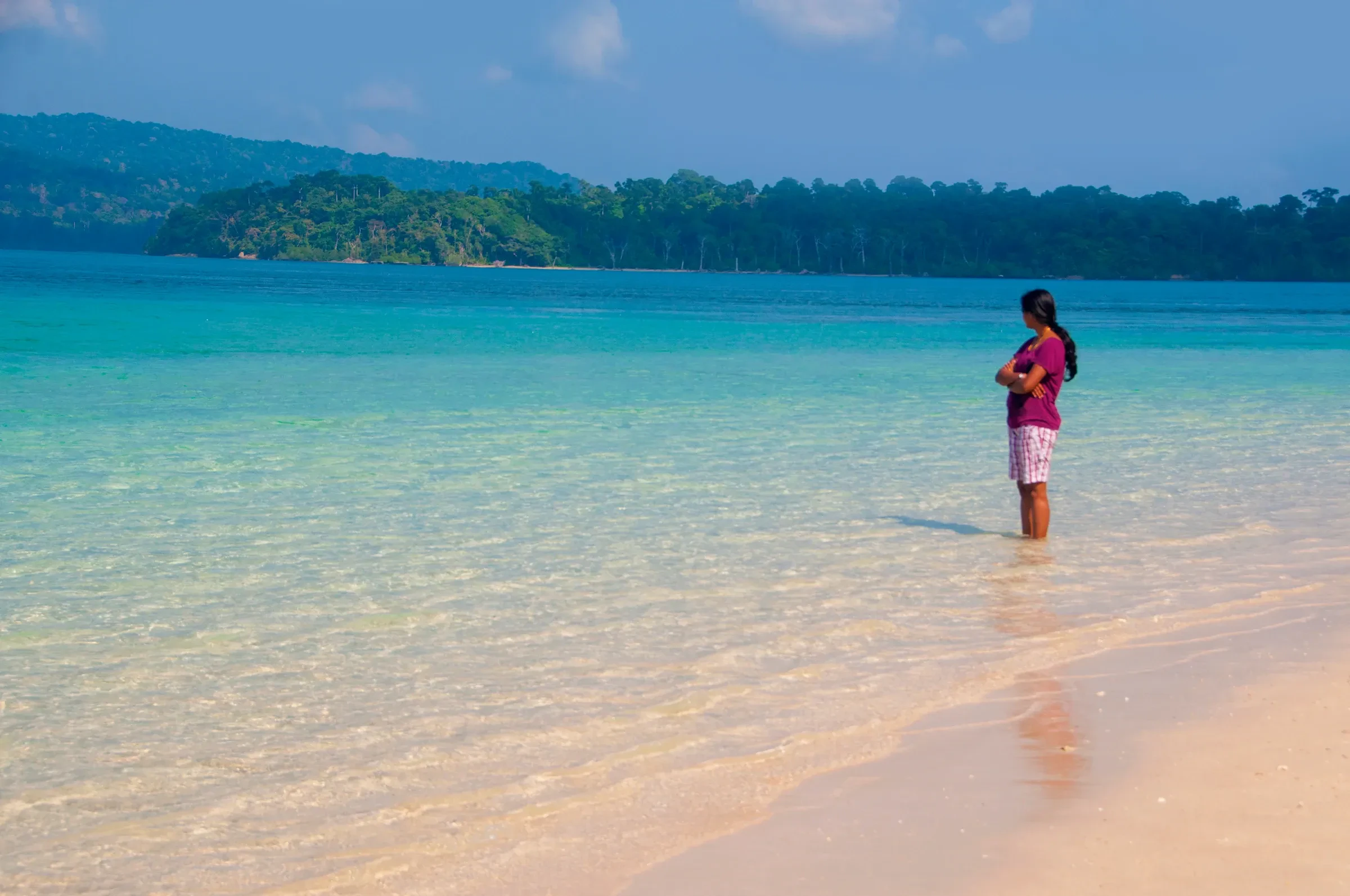 A quiet beach with clear turquoise shallows in the Andaman Islands