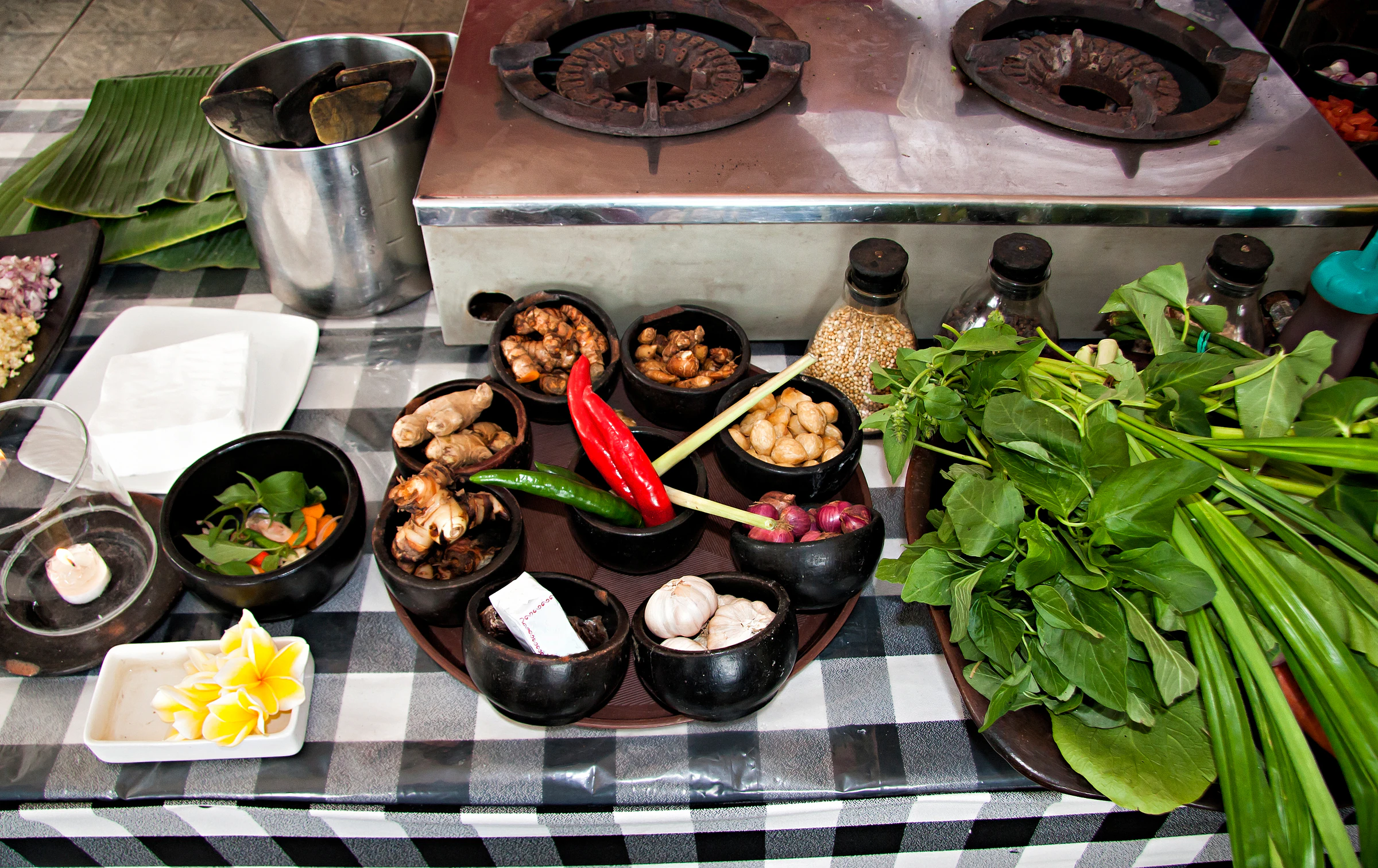 A table of bowls of fresh spices and herbs set out for a cooking class