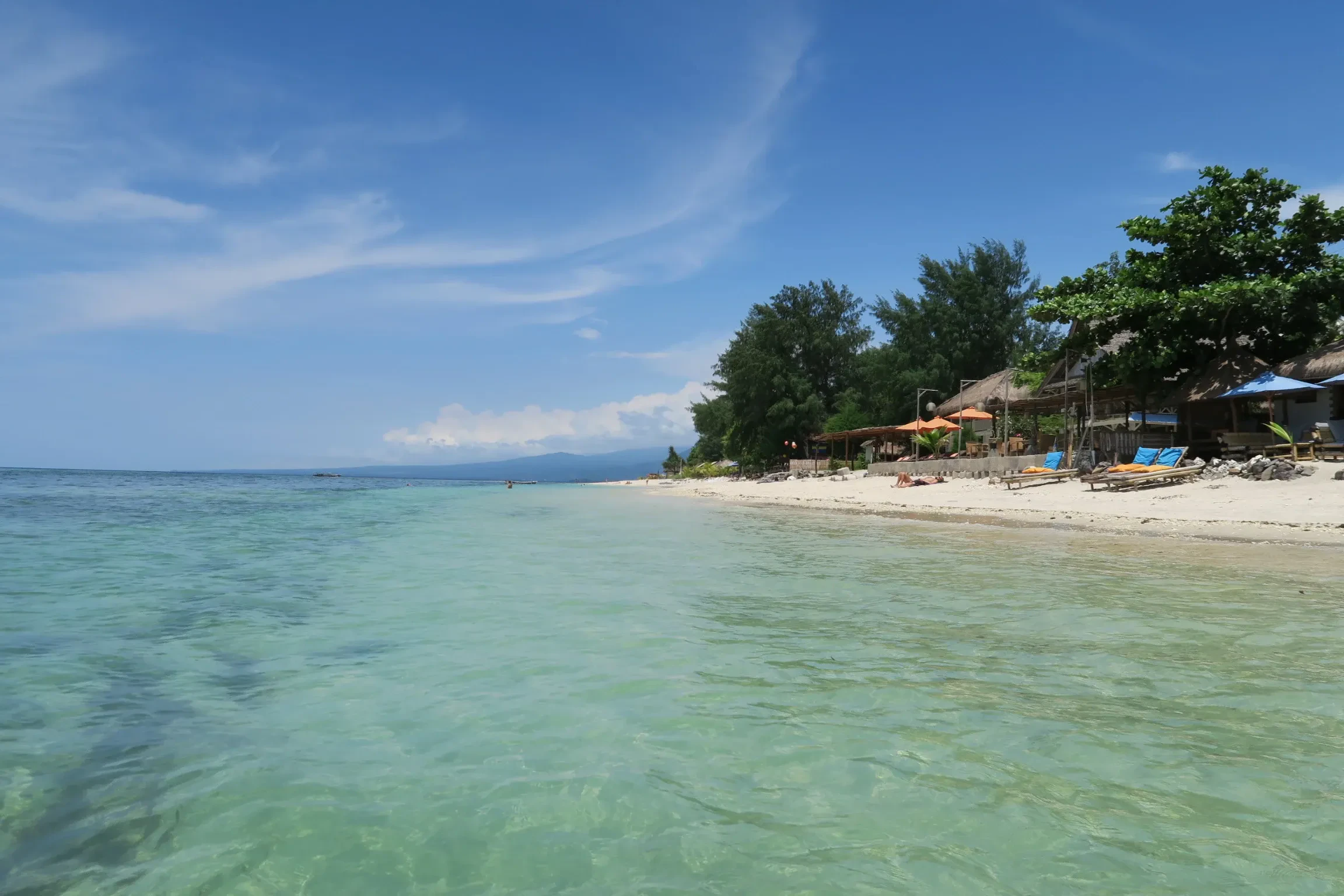 The clear shallow water and beach huts on the west side of Gili Air
