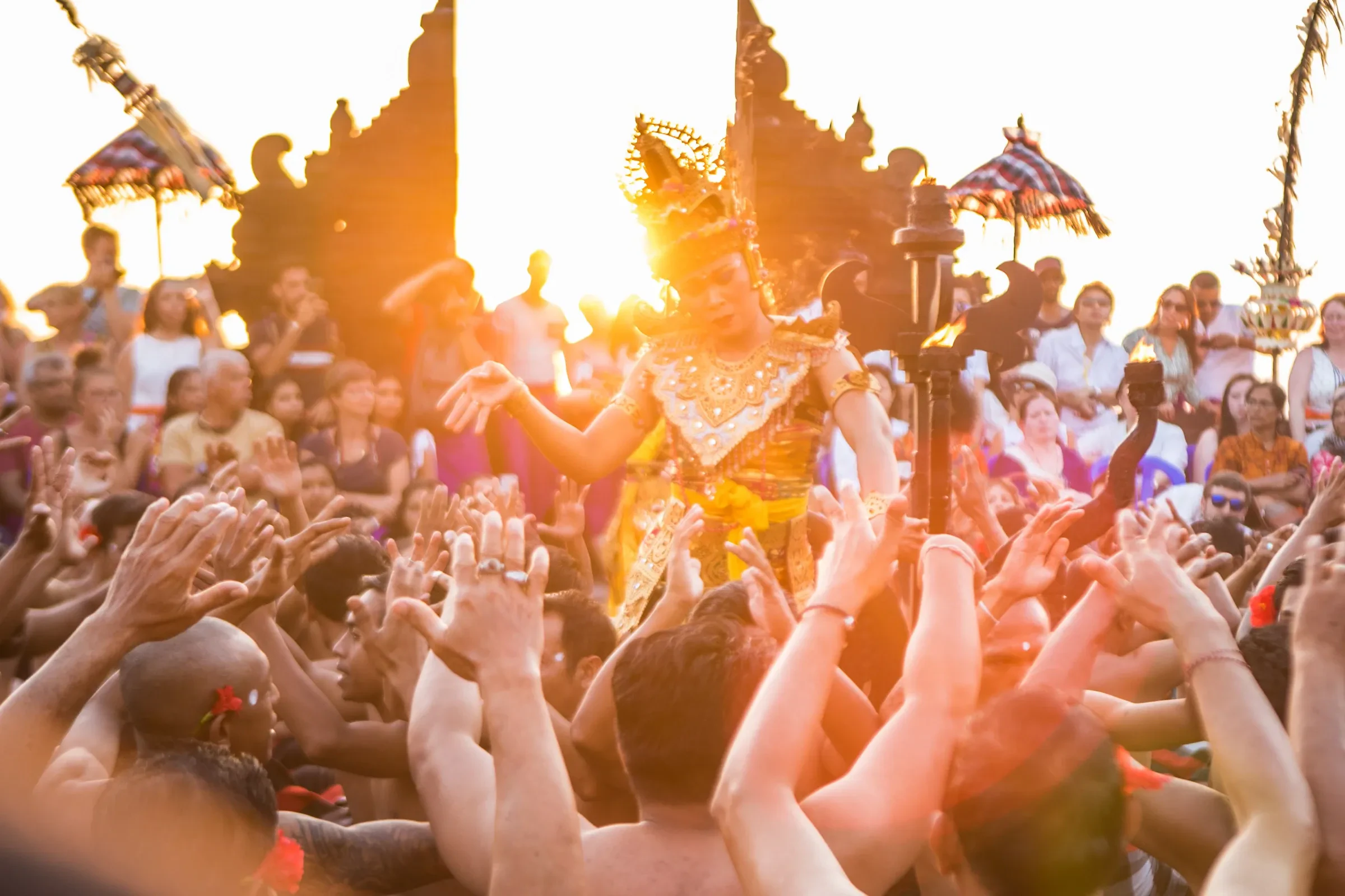 A Kecak performance at sunset at Uluwatu Temple, with a dancer among the chanting men