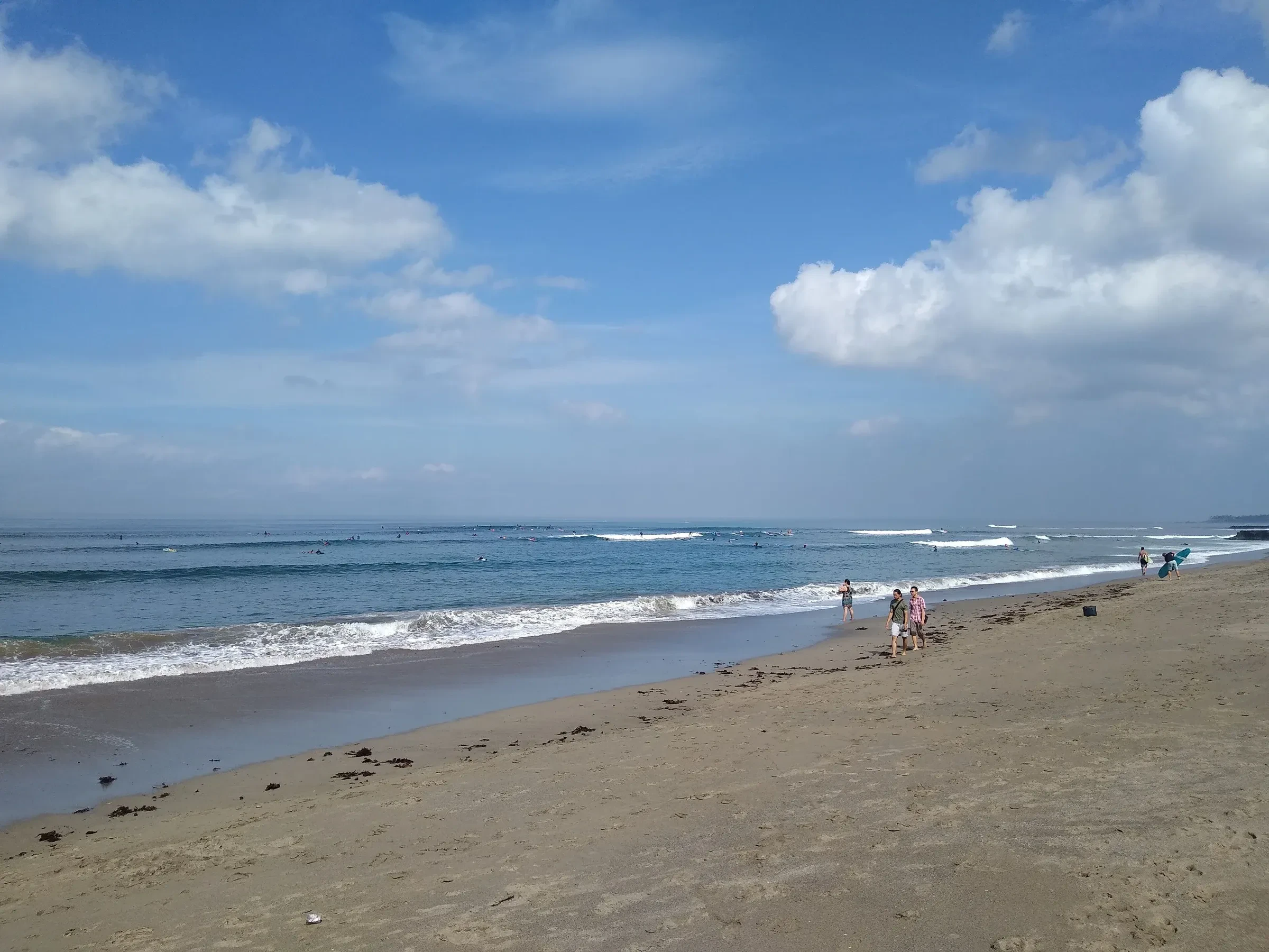 Waves rolling onto the sand of Canggu beach