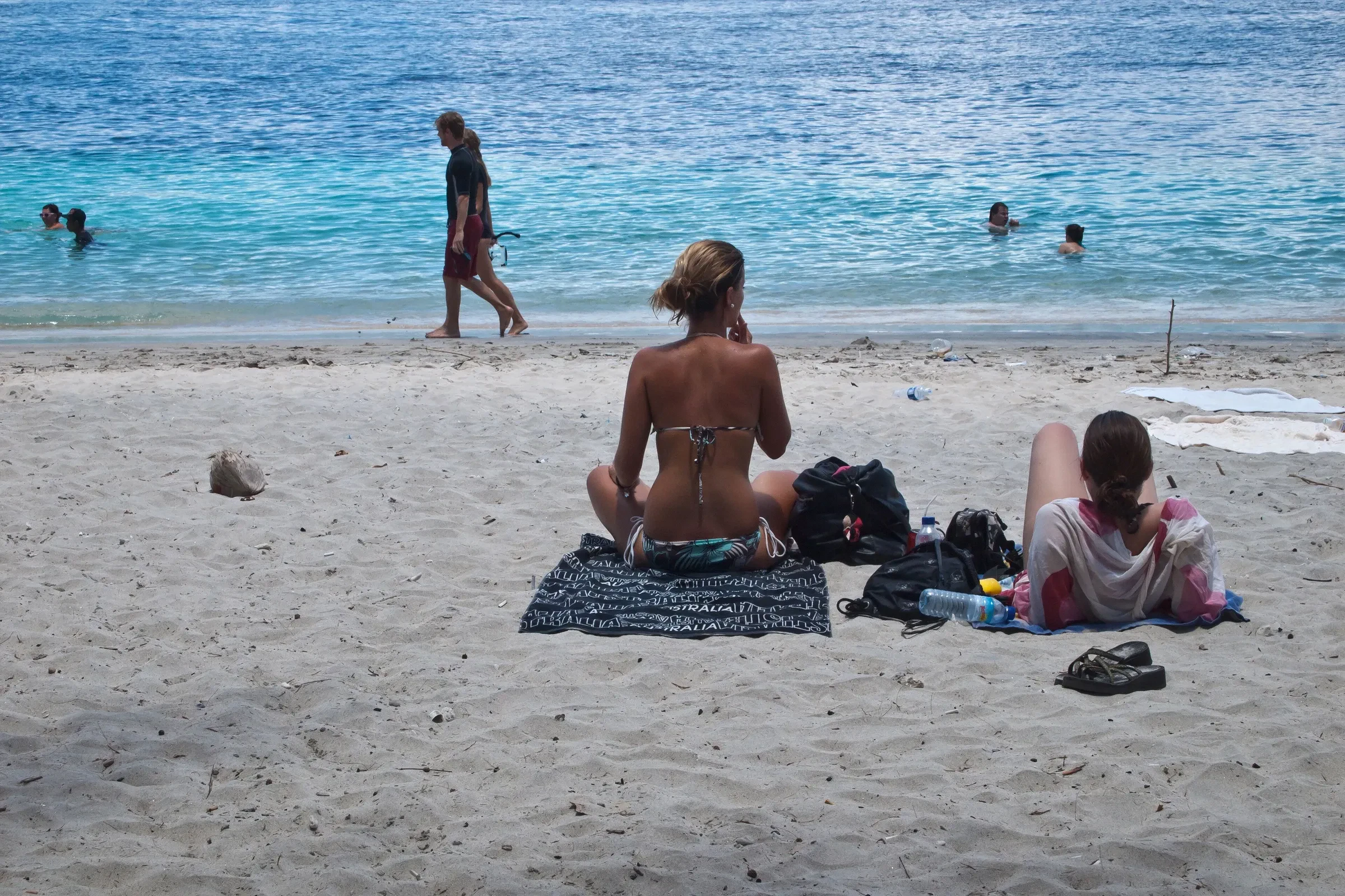 Two travellers sitting on the sand at Gili Trawangan looking out to sea