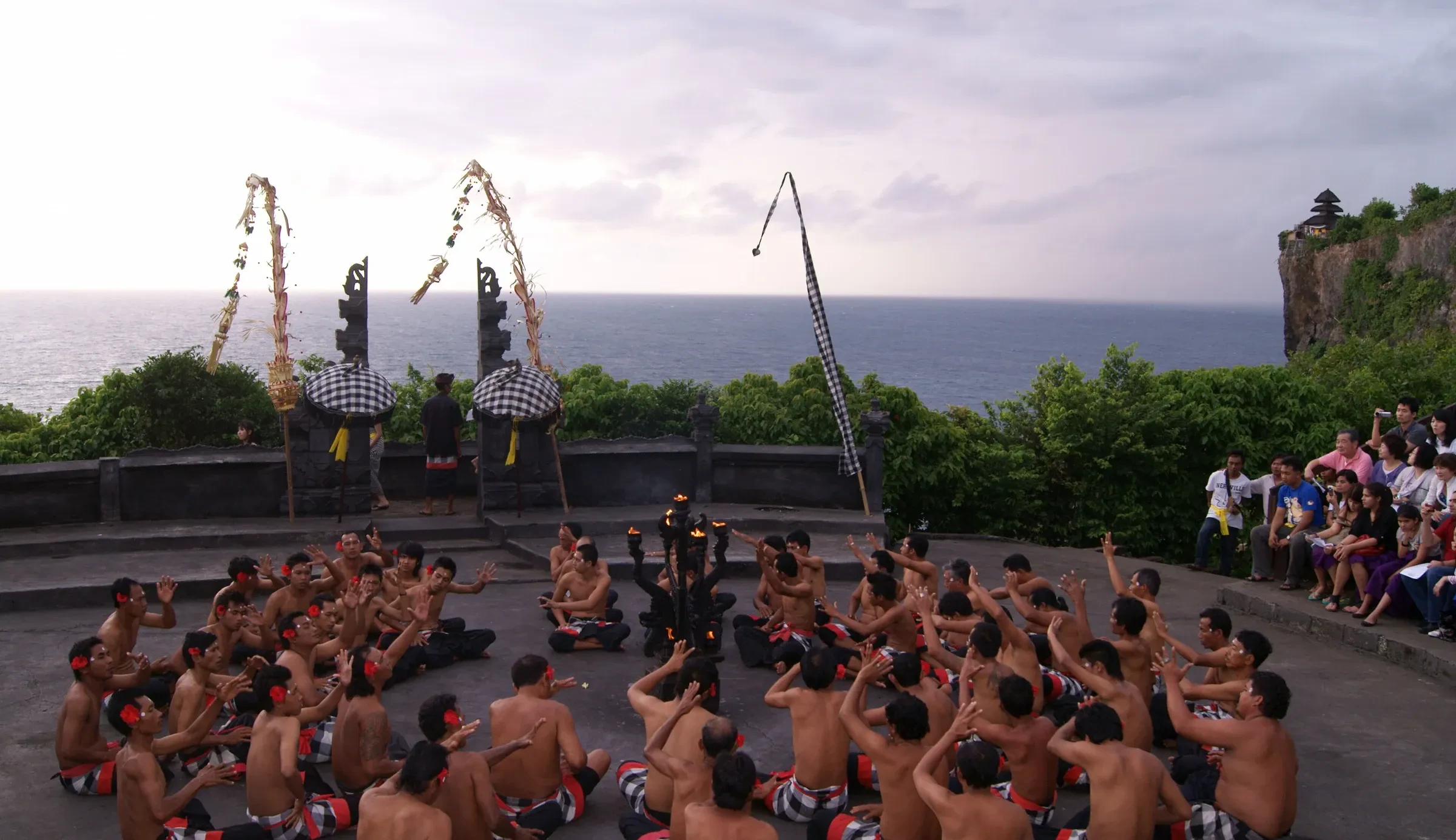 Kecak dancers seated in a circle during a performance at Uluwatu Temple on the cliff top