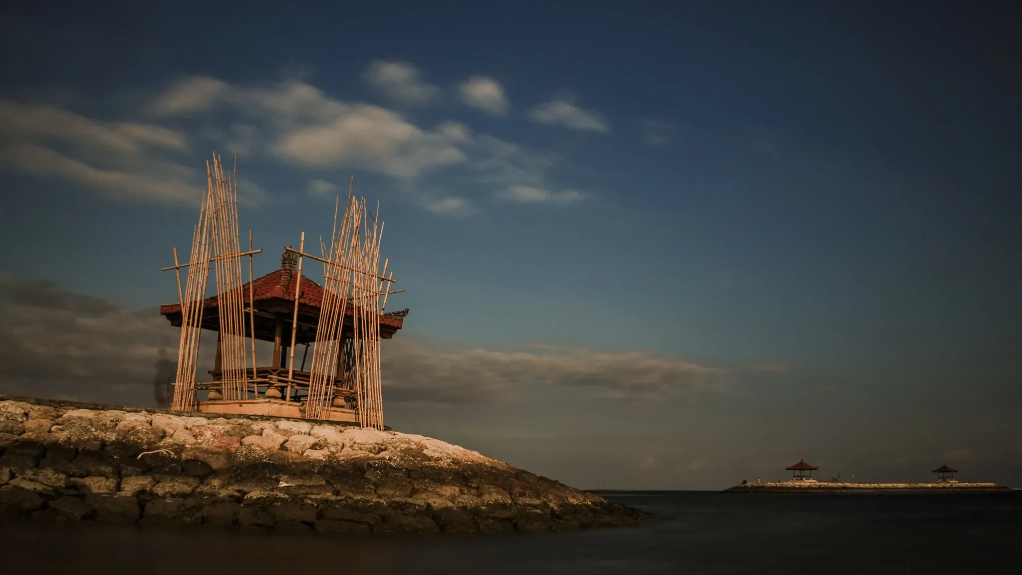 A bamboo pavilion on the Sanur shoreline at dusk