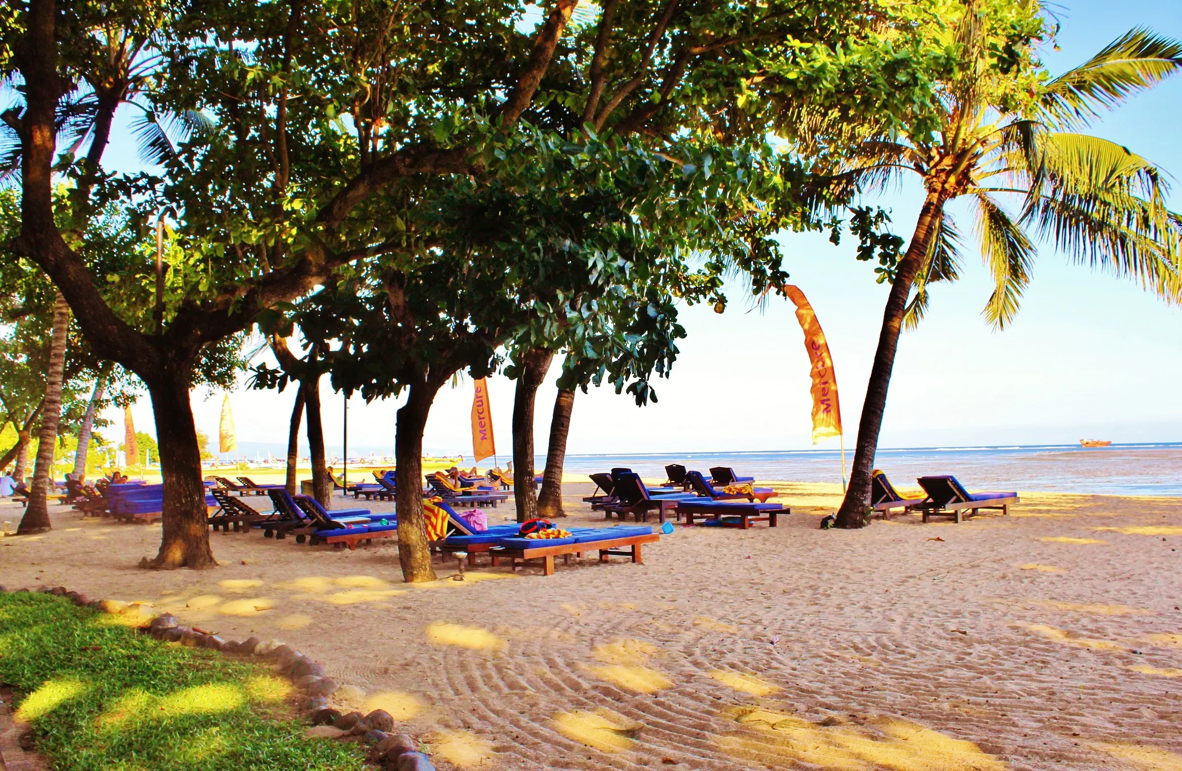 Sun loungers under trees on Sanur Beach