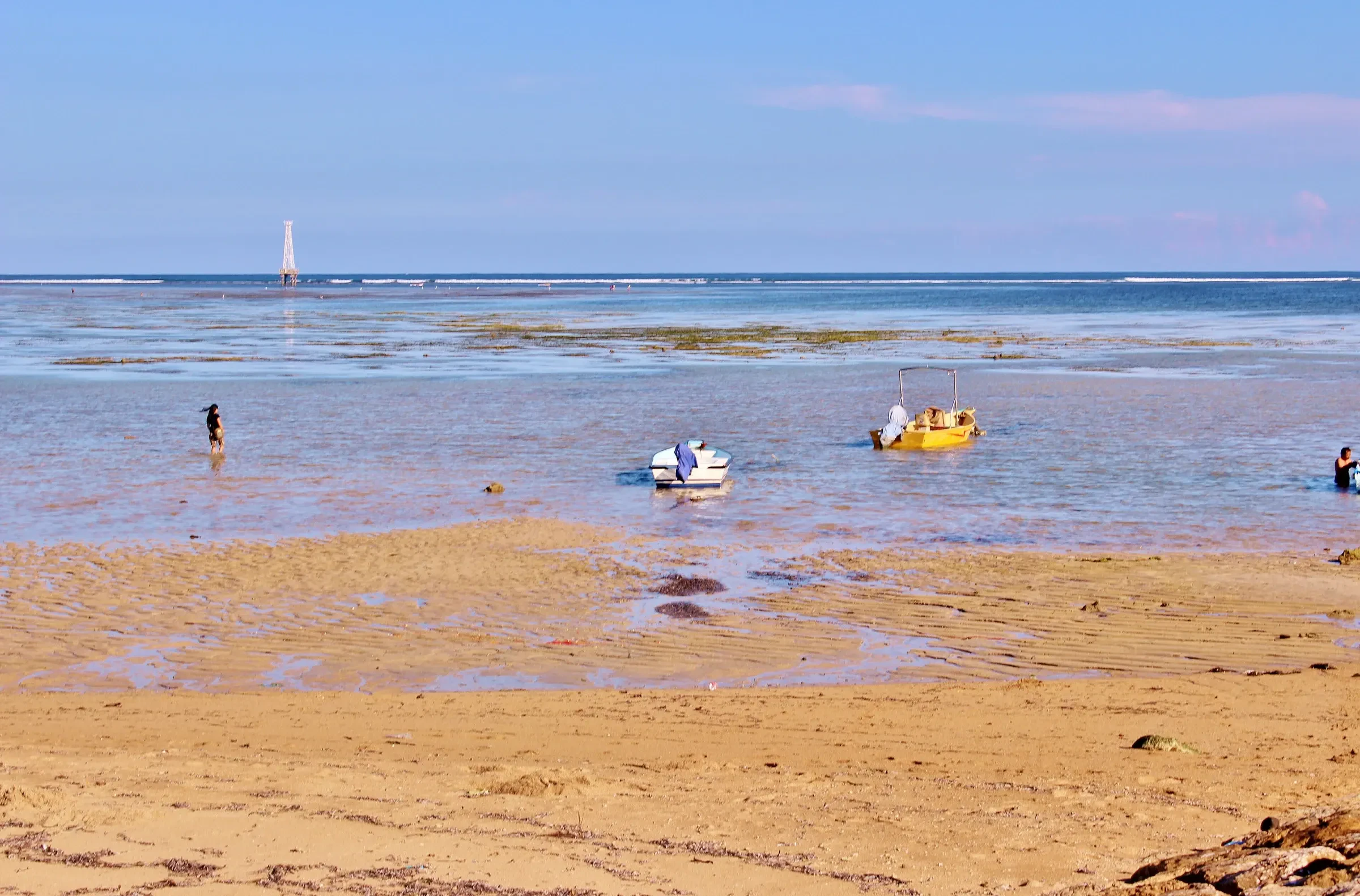 Boats on the shallow reef flat at low tide off Sanur Beach
