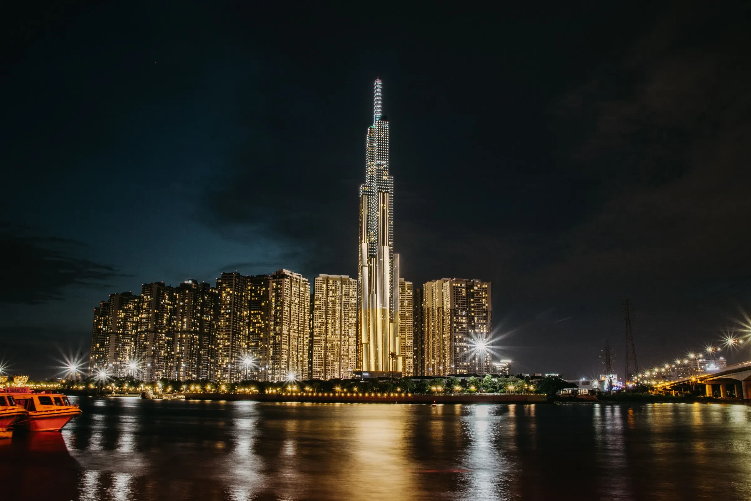 Landmark 81 tower and the Saigon River lit up at night