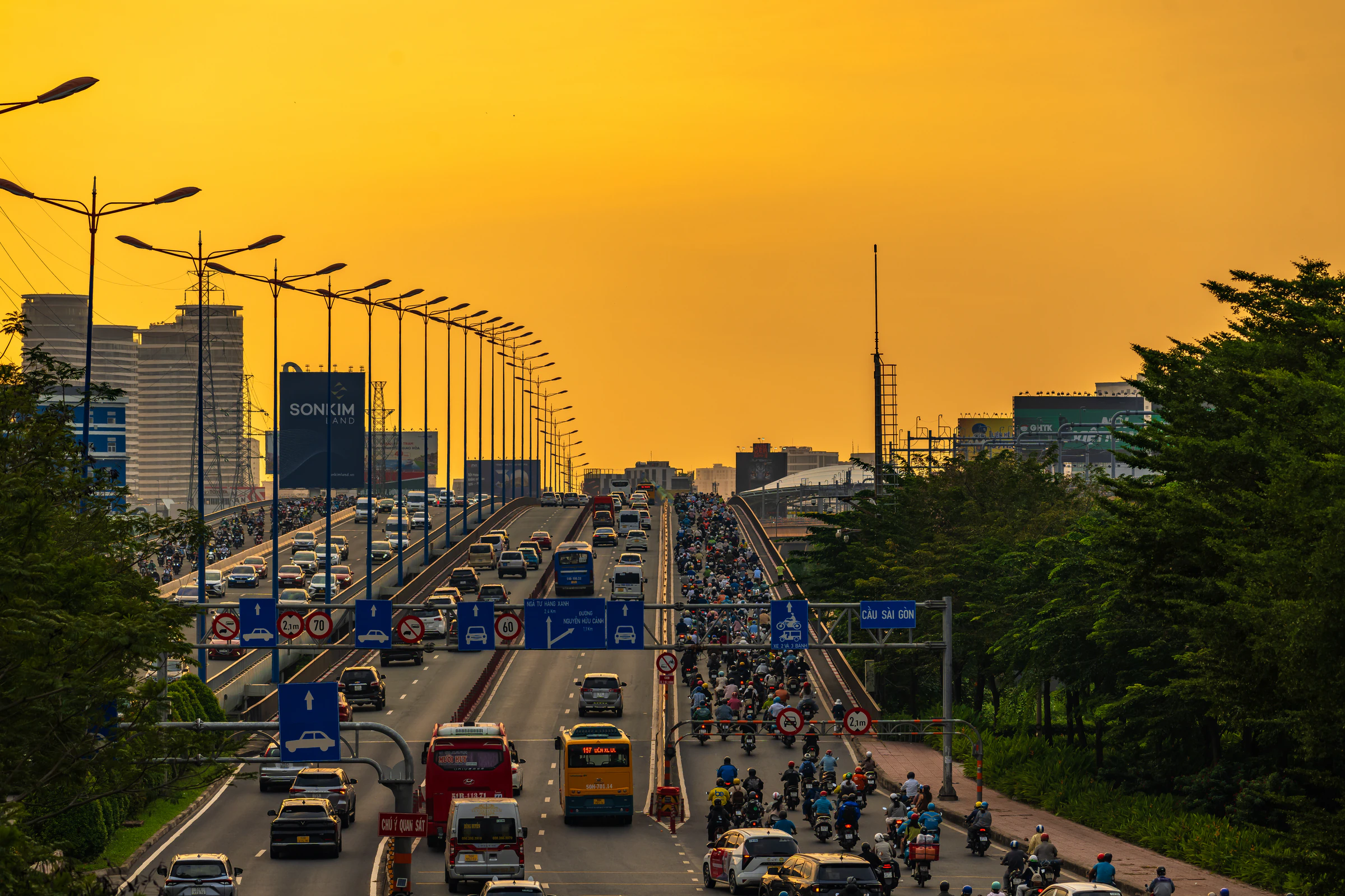 Rush-hour traffic and motorbikes on a Saigon road at sunset