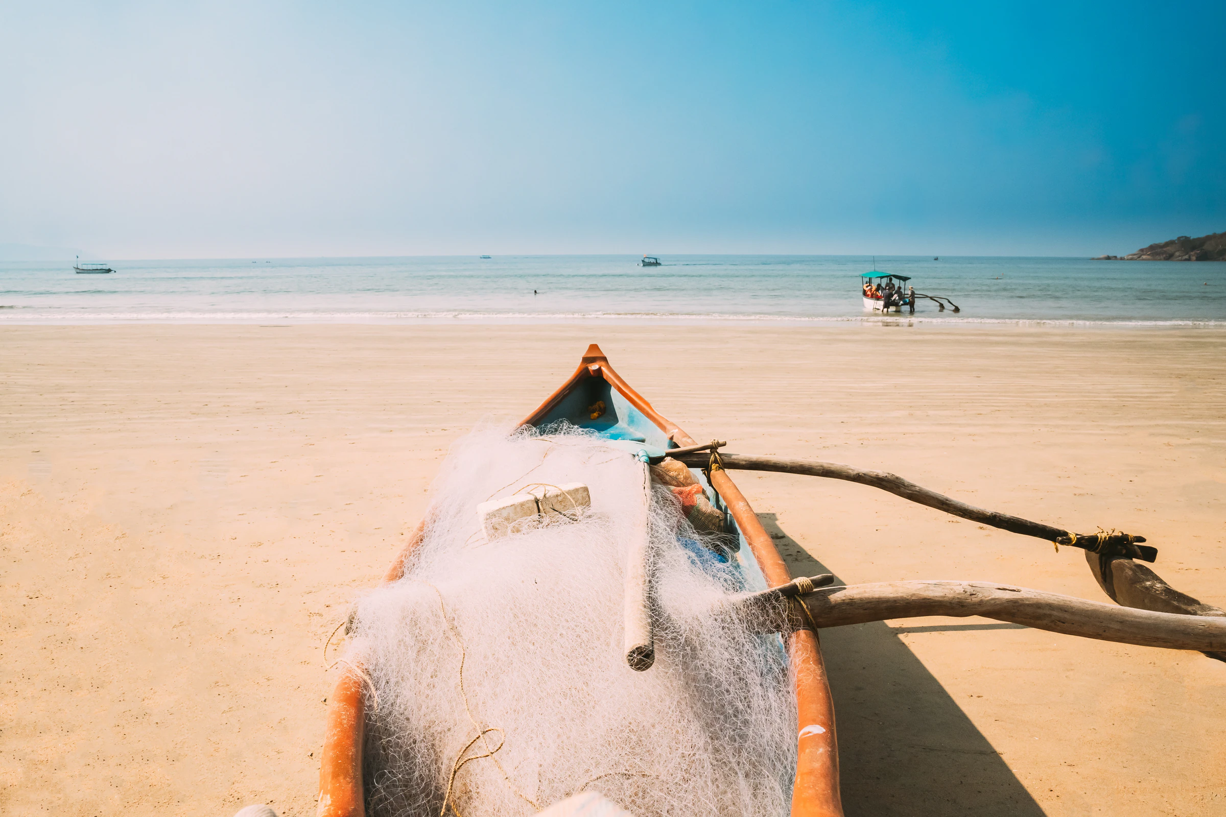 A wooden fishing boat with its net pulled up on the sand at Palolem beach