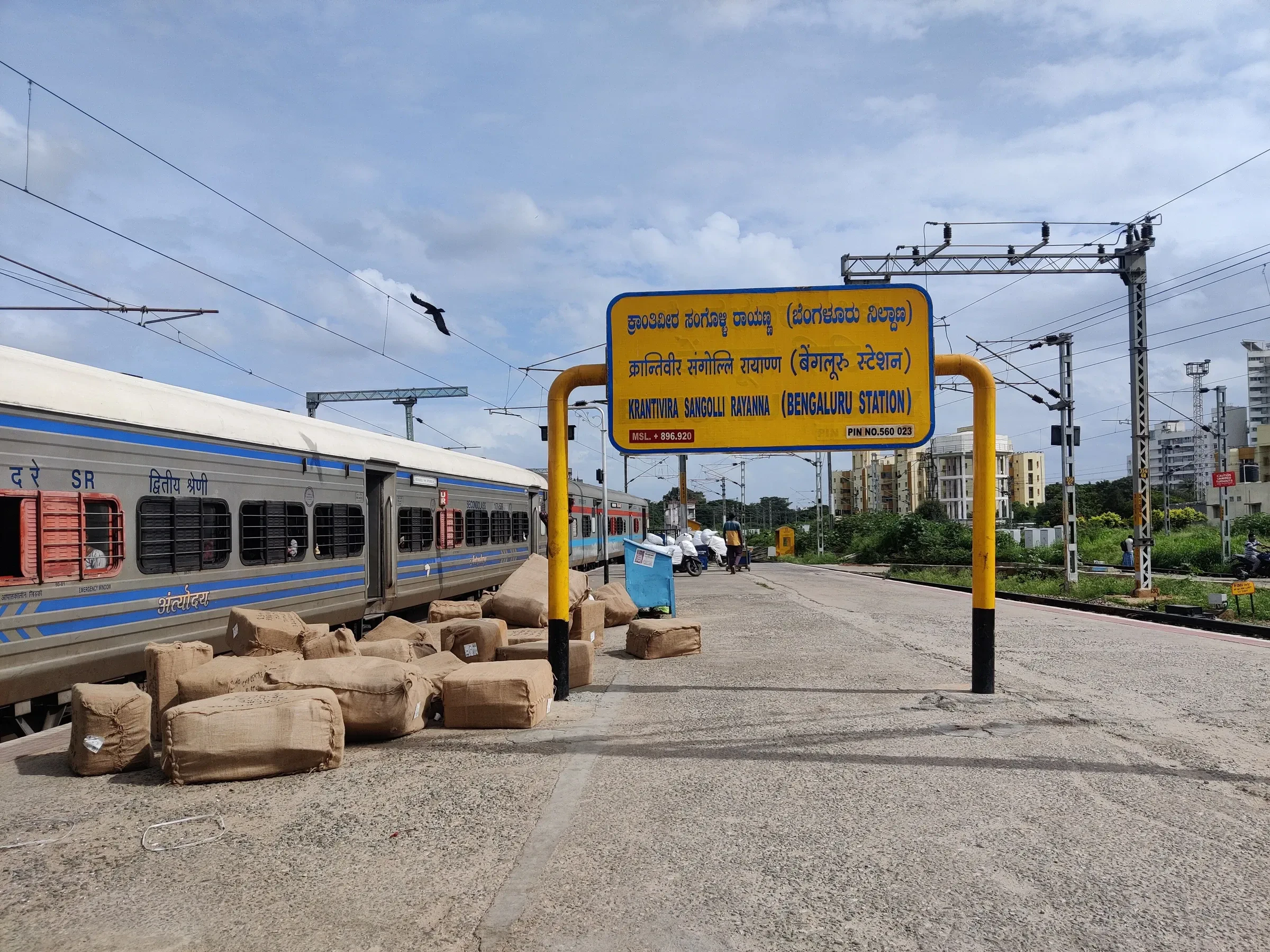 A passenger train beside the Bengaluru station sign board at KSR Bengaluru