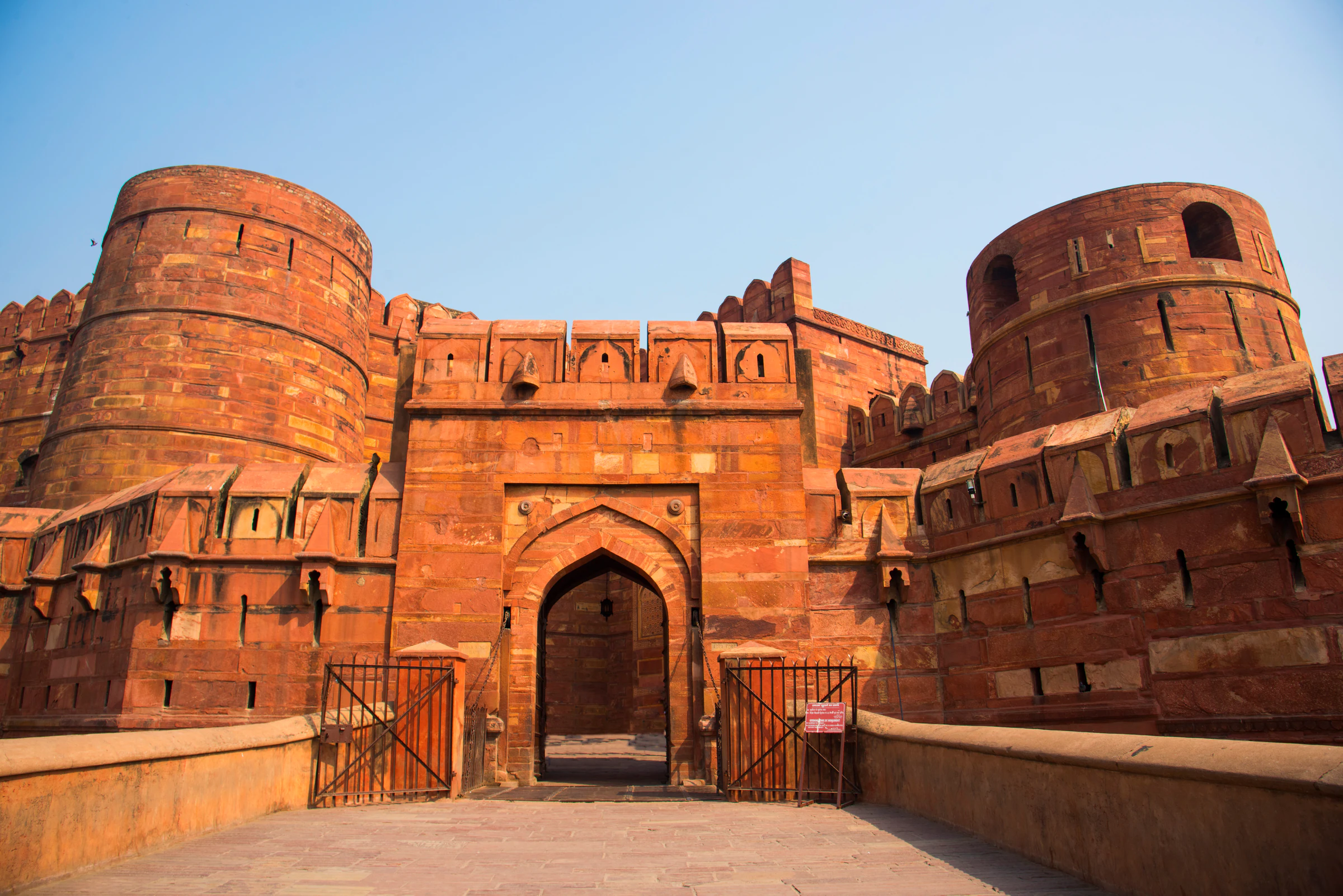 A red sandstone gateway and towers of Agra Fort