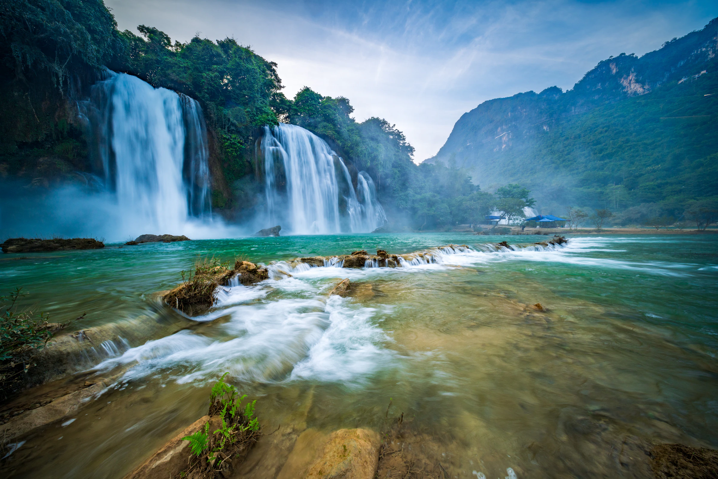 Ban Gioc Waterfall flowing over wide limestone tiers on the Chinese border