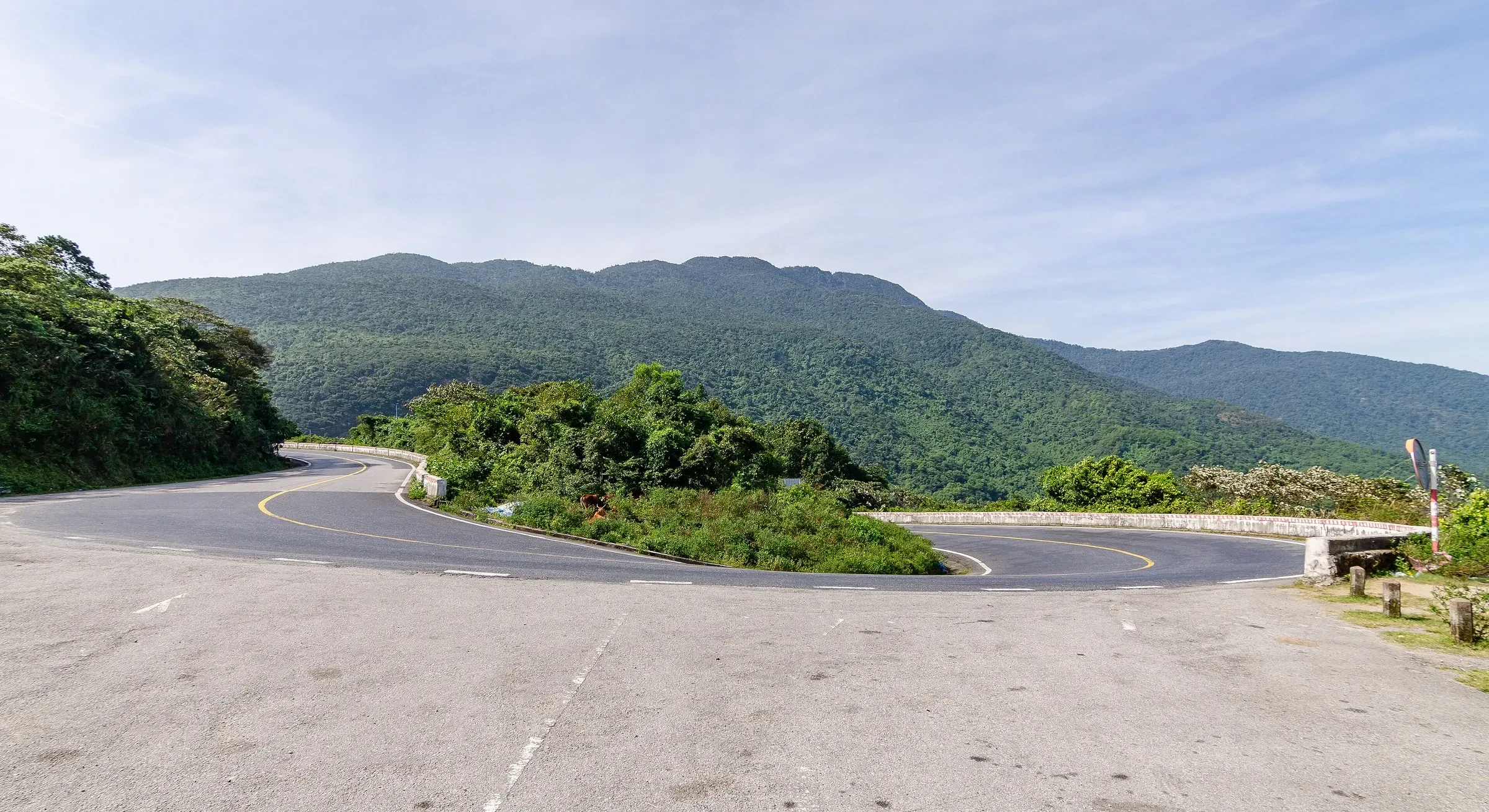 A hairpin bend on the Hai Van Pass road, with forested hills behind