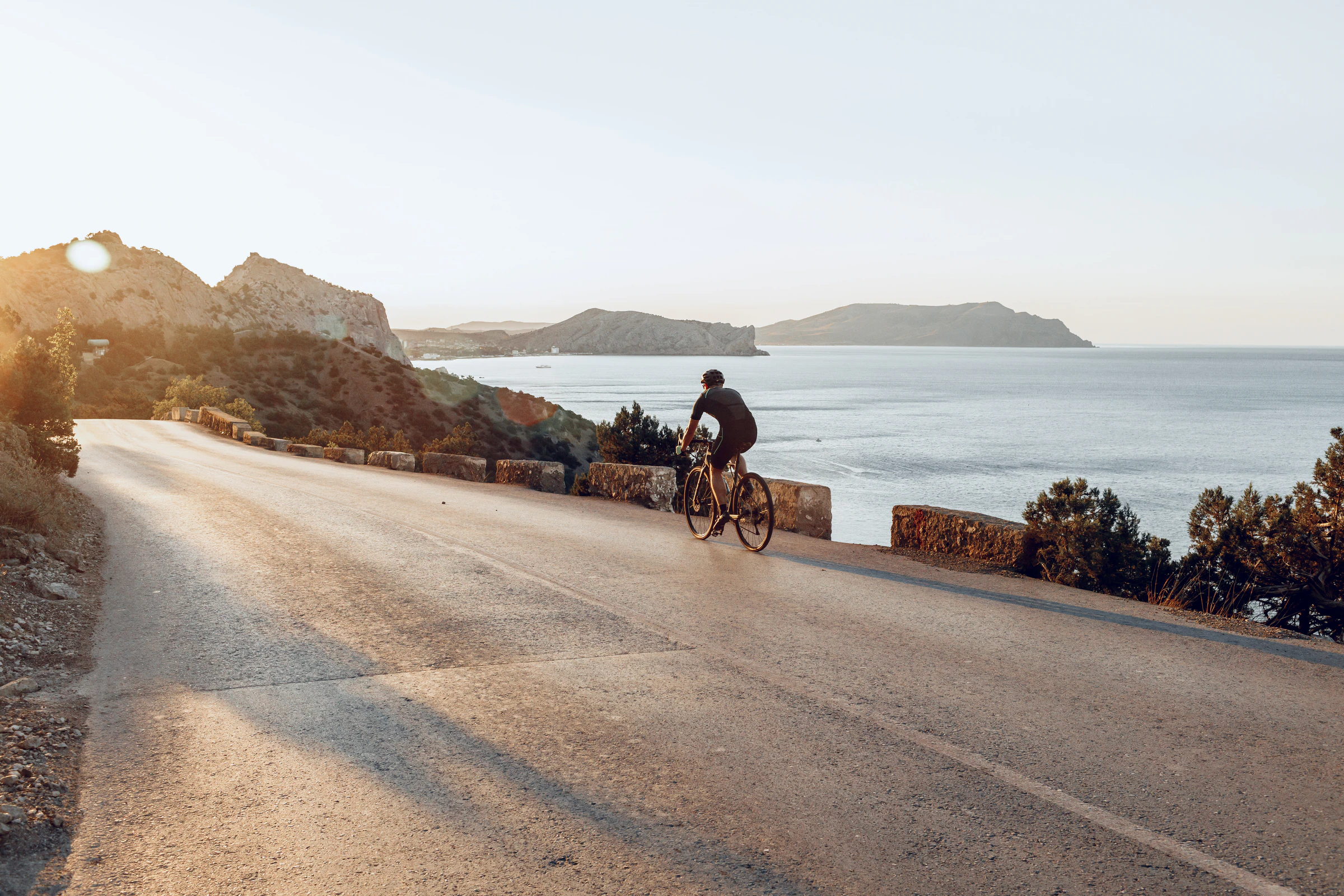 A cyclist riding along a coastal road