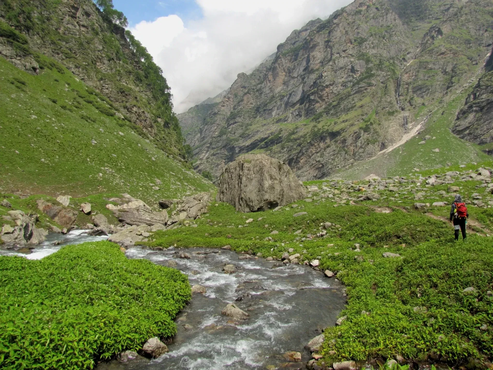 A hiker beside a mountain stream on the trail between Balu Ka Ghera and Jobra