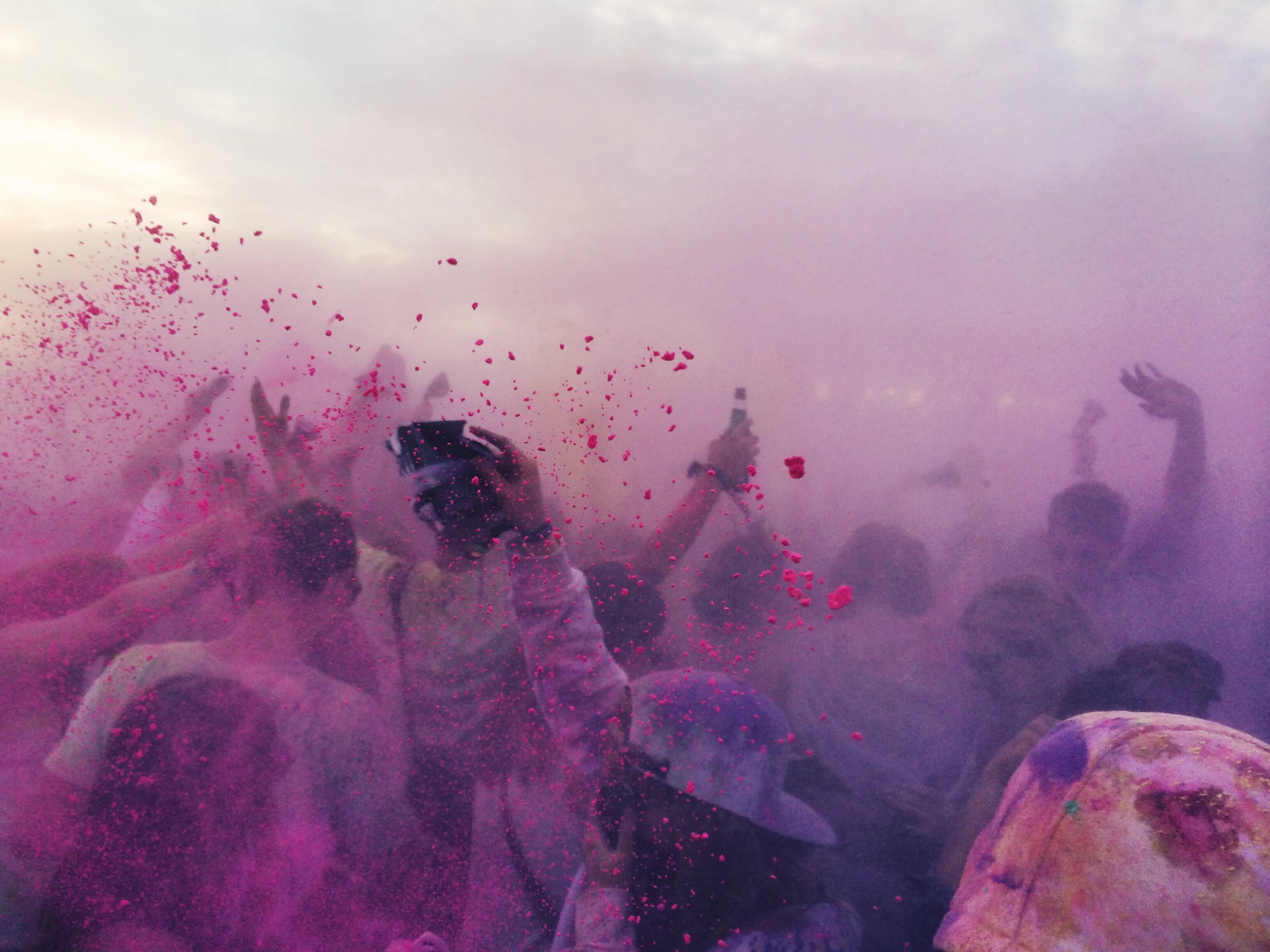 Crowds throwing coloured powder into the air during Holi celebrations in India