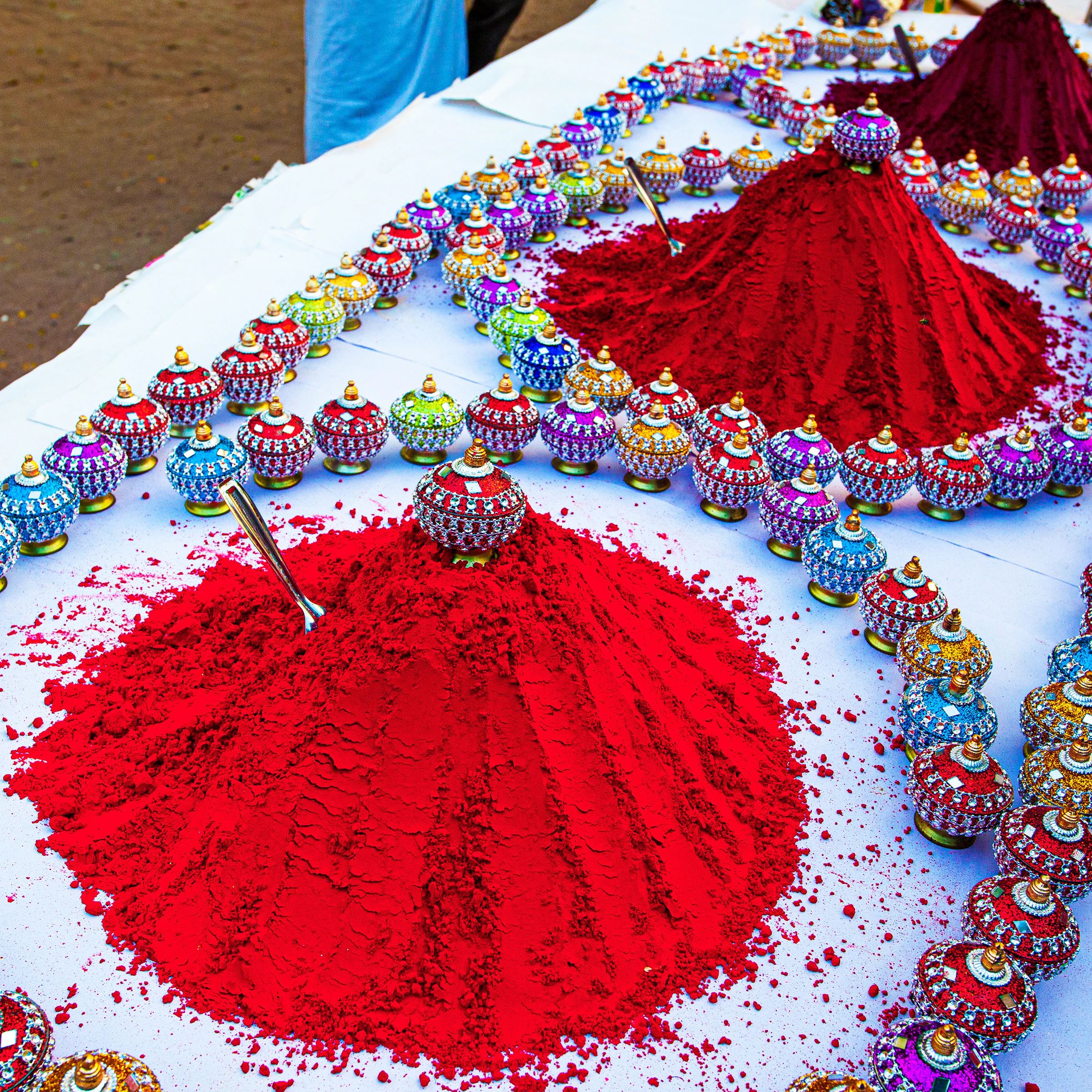 Mounds of coloured turmeric powder for sale ahead of Holi